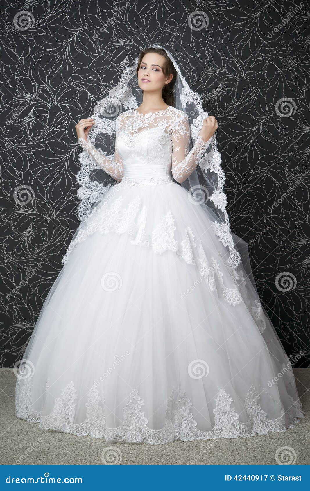 Fashionable White Gown, Beautiful Blonde Model, Bride Hairstyle And Makeup  Concept - Slim Young Woman In Cute Wedding Dress Standing Indoors On Light  Background, Attractive Girl Posing Near Curtains Stock Photo, Picture