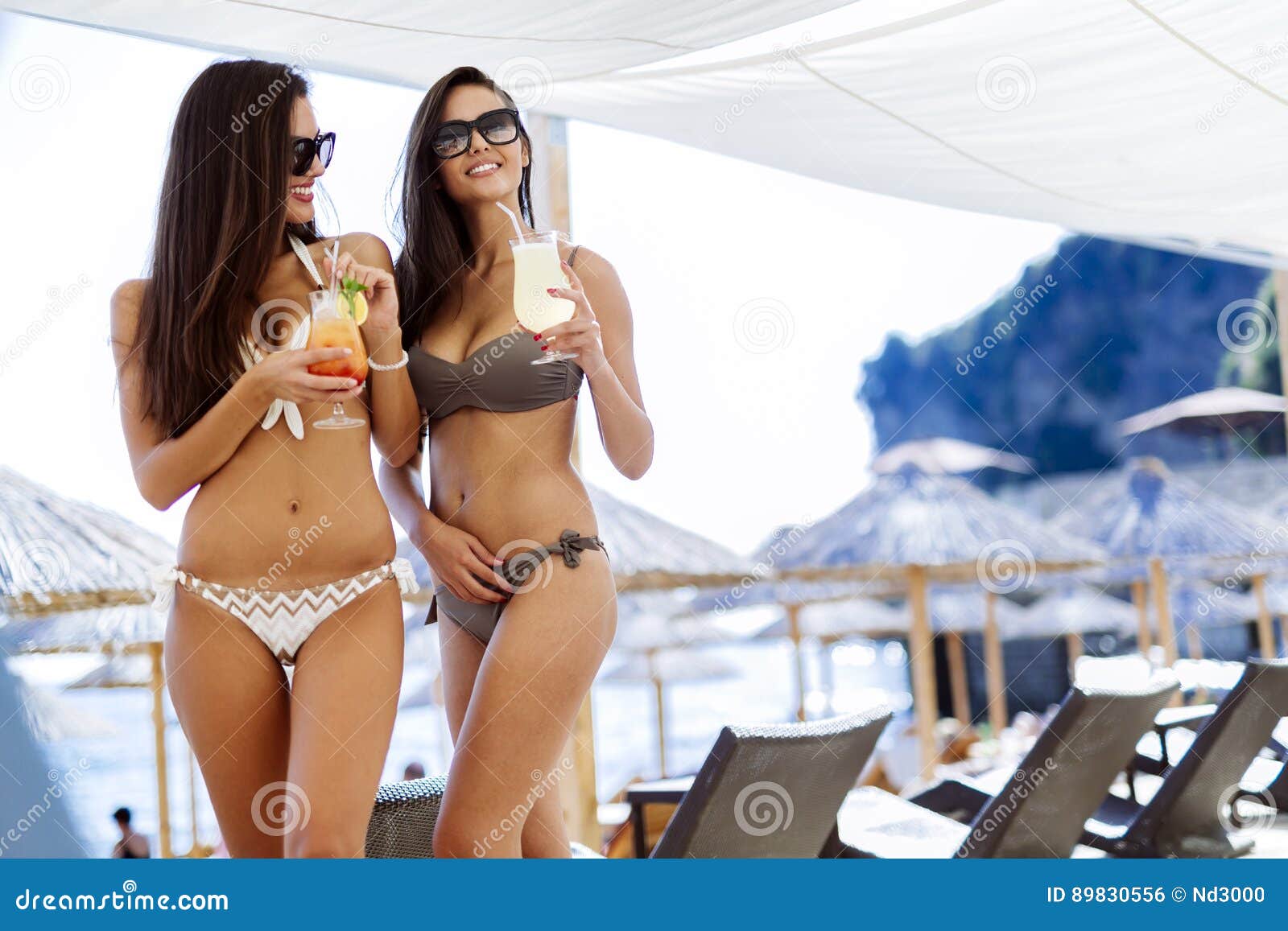 Beautiful Women on Beach Drinking Cocktails Stock Photo picture
