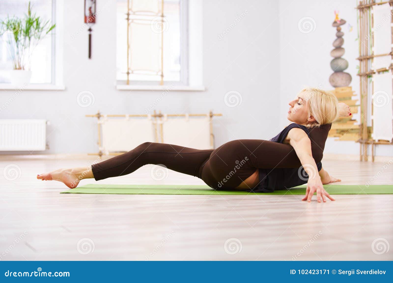 Woman practicing yoga, lying in Savasana, Dead Body pose Stock Photo - Alamy