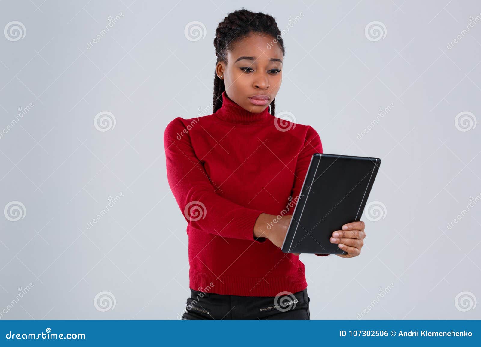 A African-American Girl Holding a Tablet Firmly and Using it with