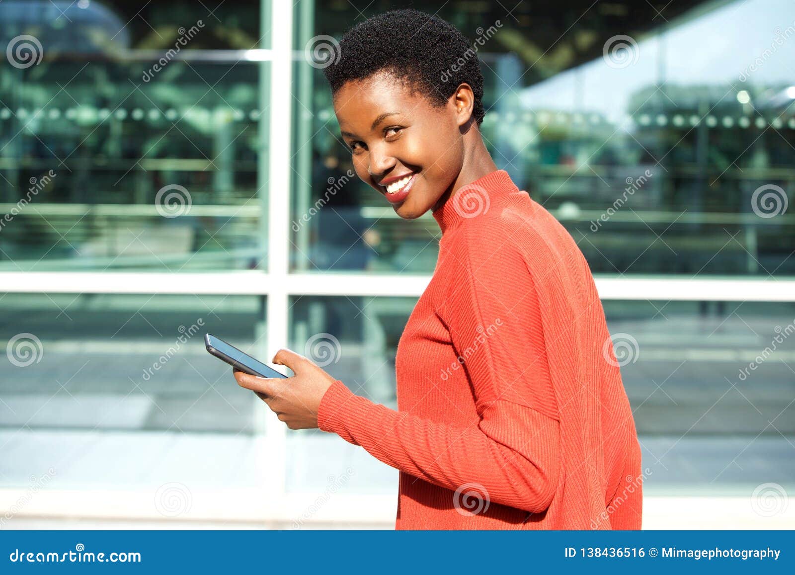 Beautiful Young African American Woman Holding Cellphone And Smiling