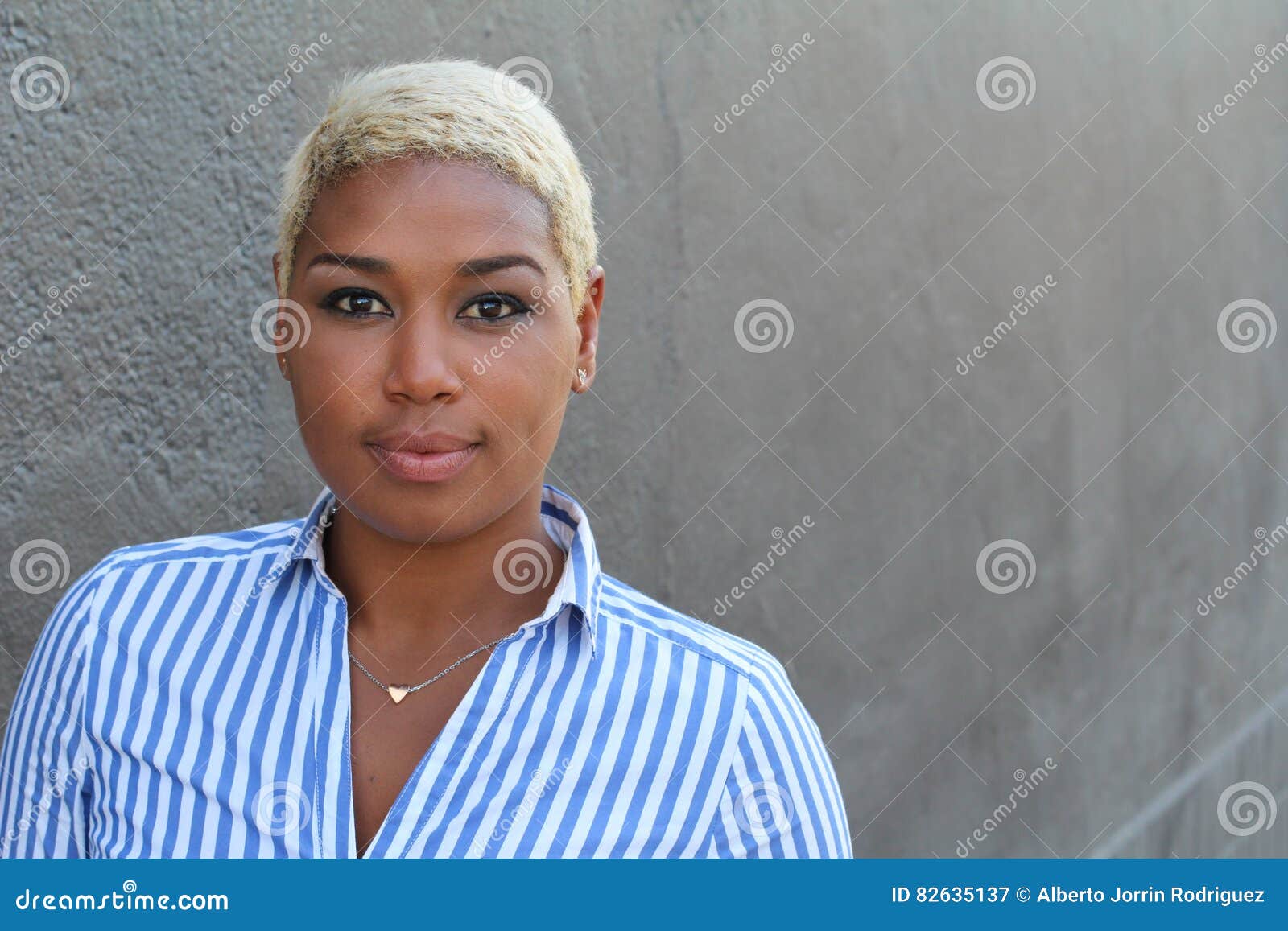 beautiful-young-african-american-woman-short-dyed-blond-hair-looking-camera-relaxed-neutral-expression-82635137.jpg