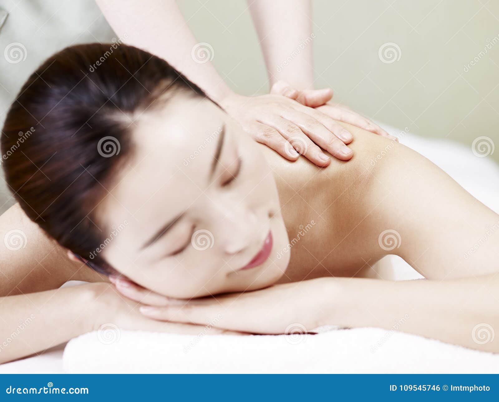 Beautiful Young Asian Woman Receiving Massage In Spa Salon