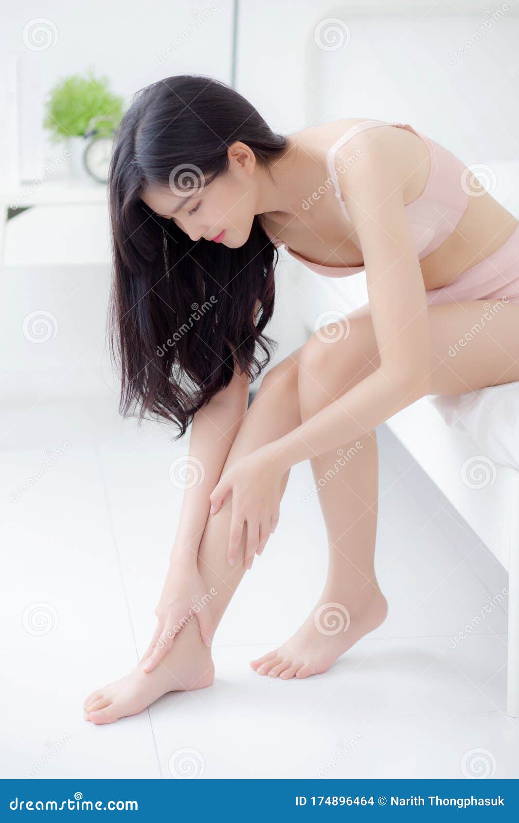 Beautiful Young Asian Woman Touch Skin Leg Smooth with Cream and