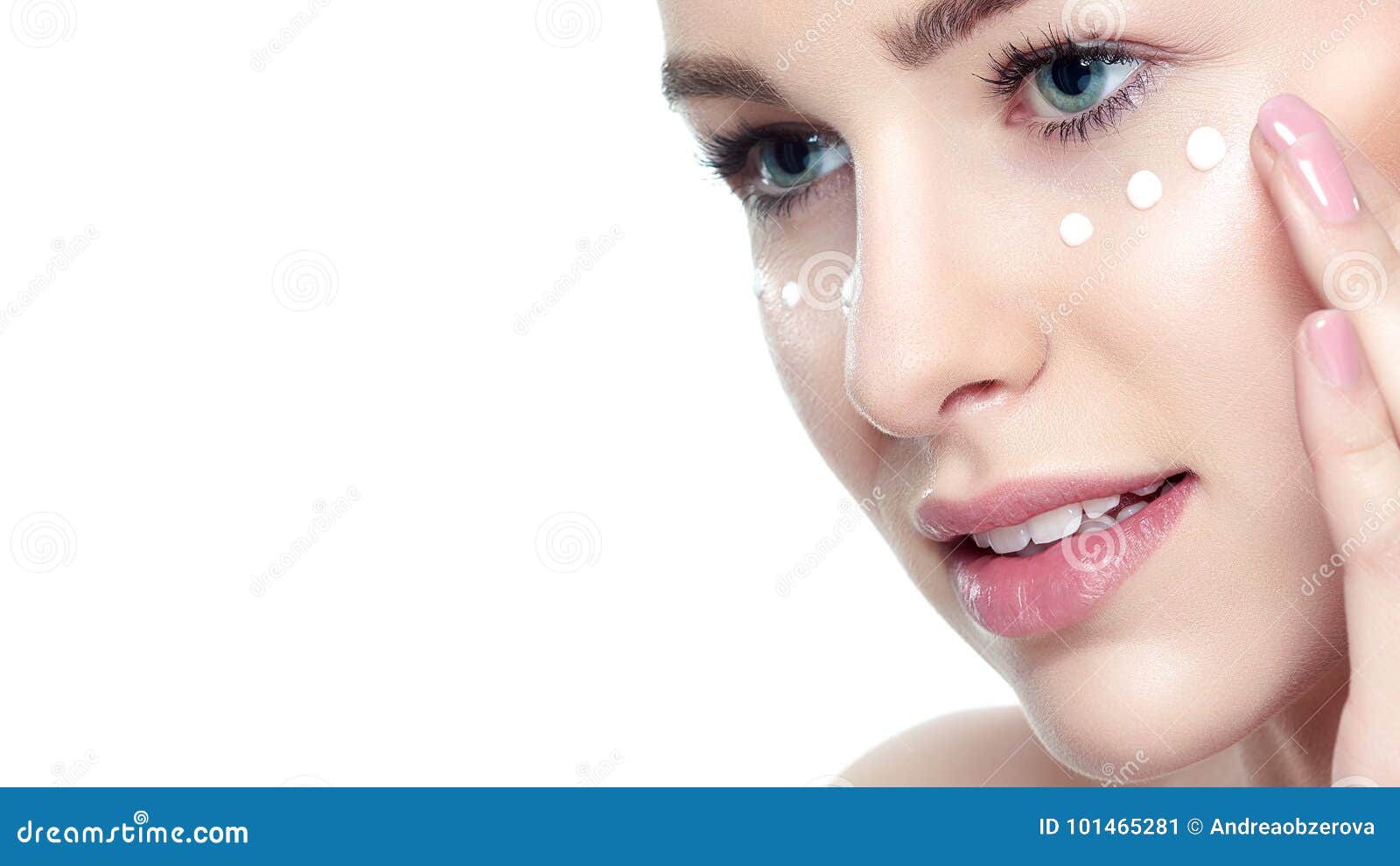 beautiful young blond woman applying face cream under her eyes. facial treatment. cosmetology, beauty and spa concept