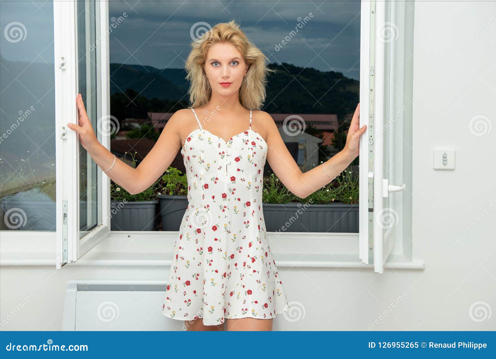 Beautiful Young Blonde Woman Standing Near The Window Stock Image