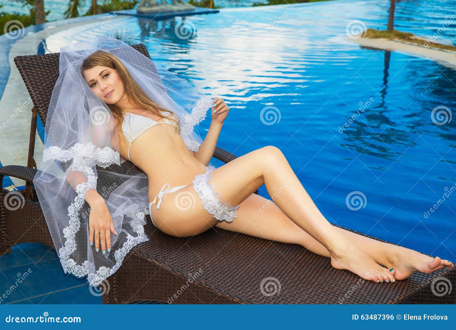 Beautiful Young Bride in a White Bikini, Veil and Garter on Her Stock Photo 