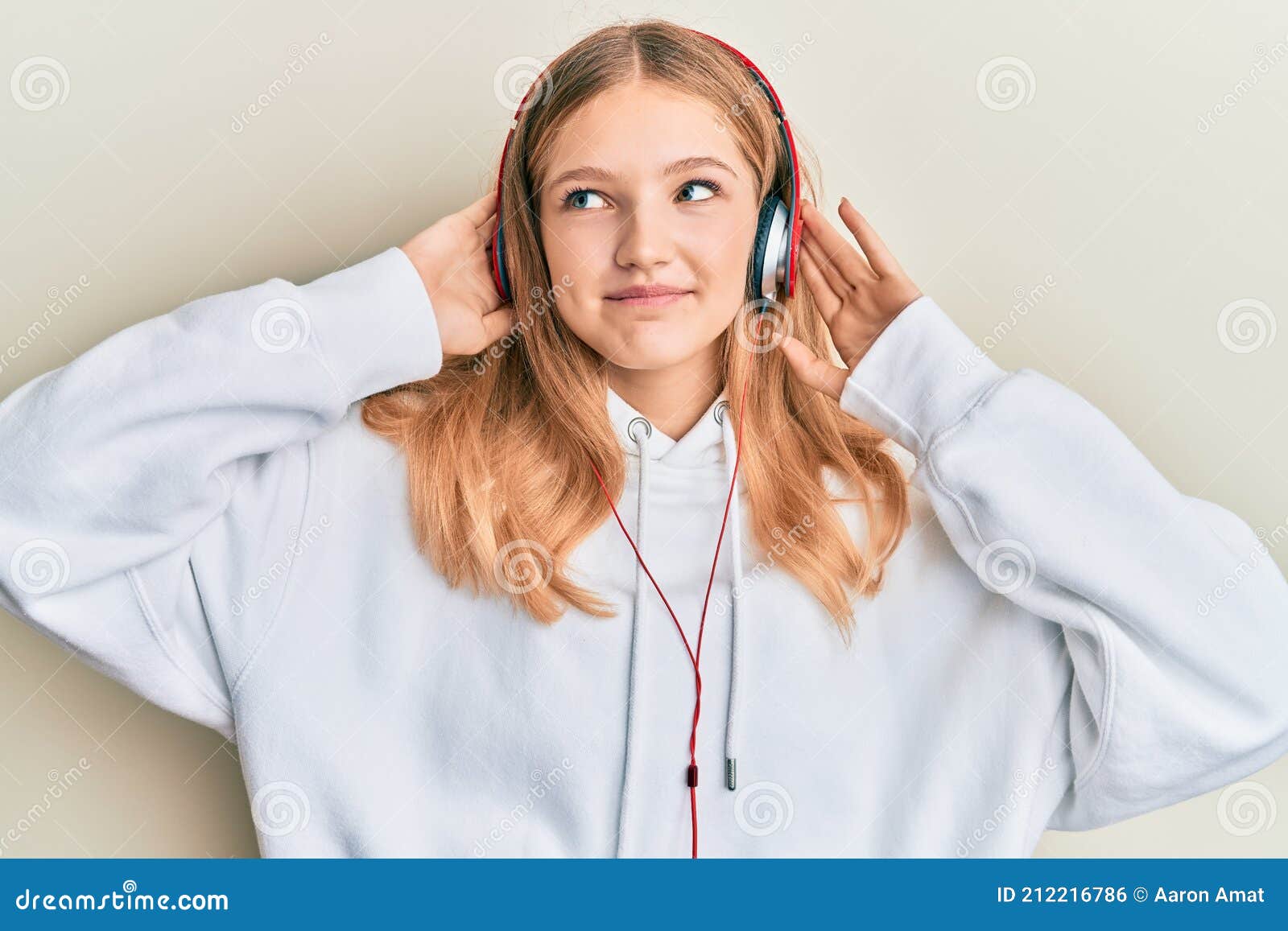 Beautiful Young Caucasian Girl Listening To Music Using Headphones