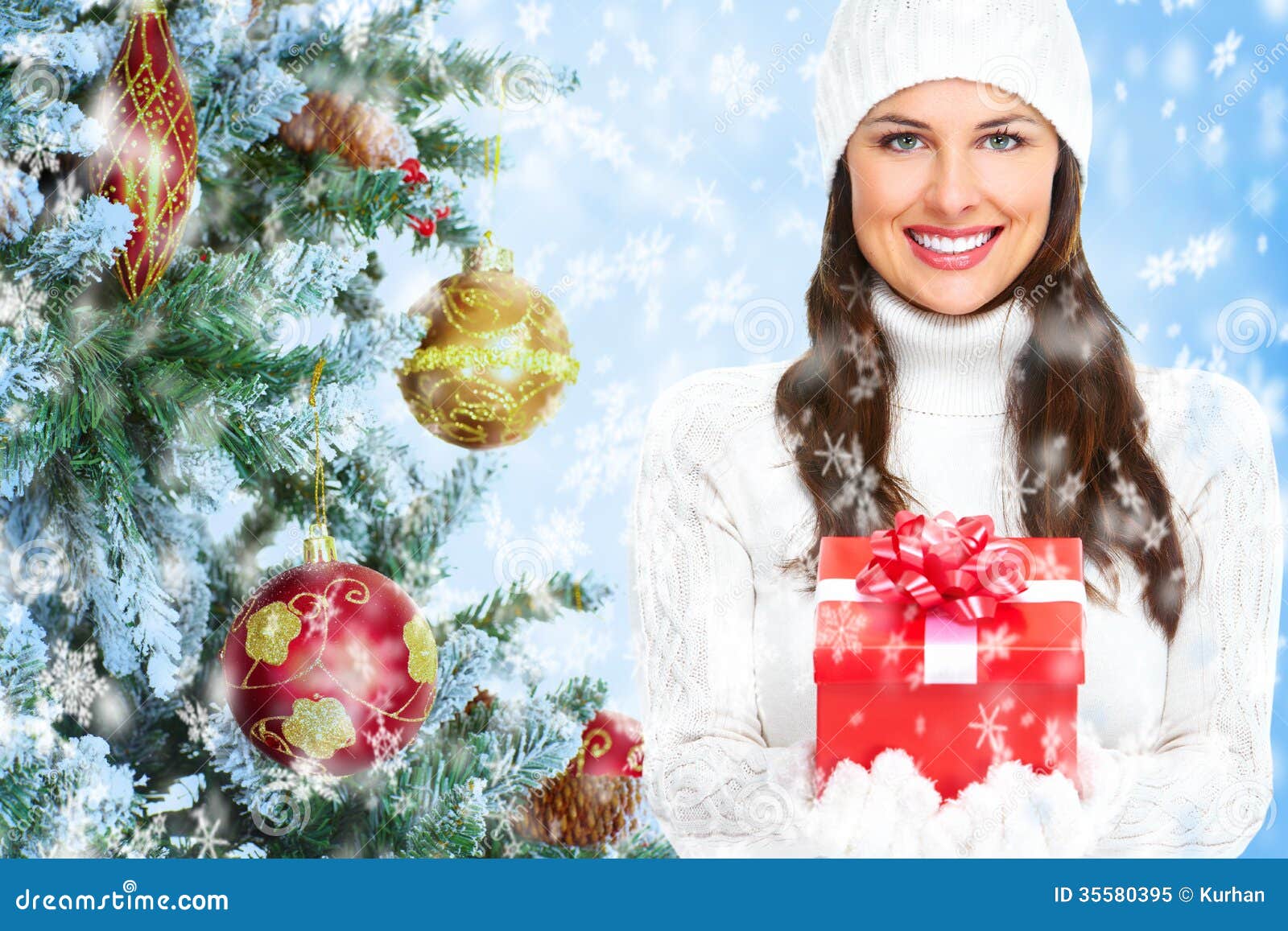 Beautiful young Christmas girl with a present. Beautiful young Christmas girl with a present over winter snowy background.