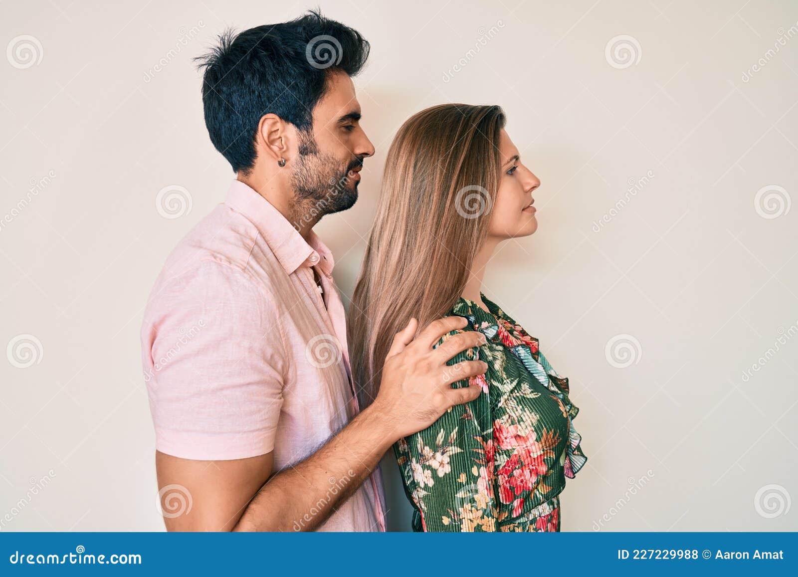 Boyfriend Kissing His Girlfriend In Front Of A Pink And Yellow Weathered  Wall