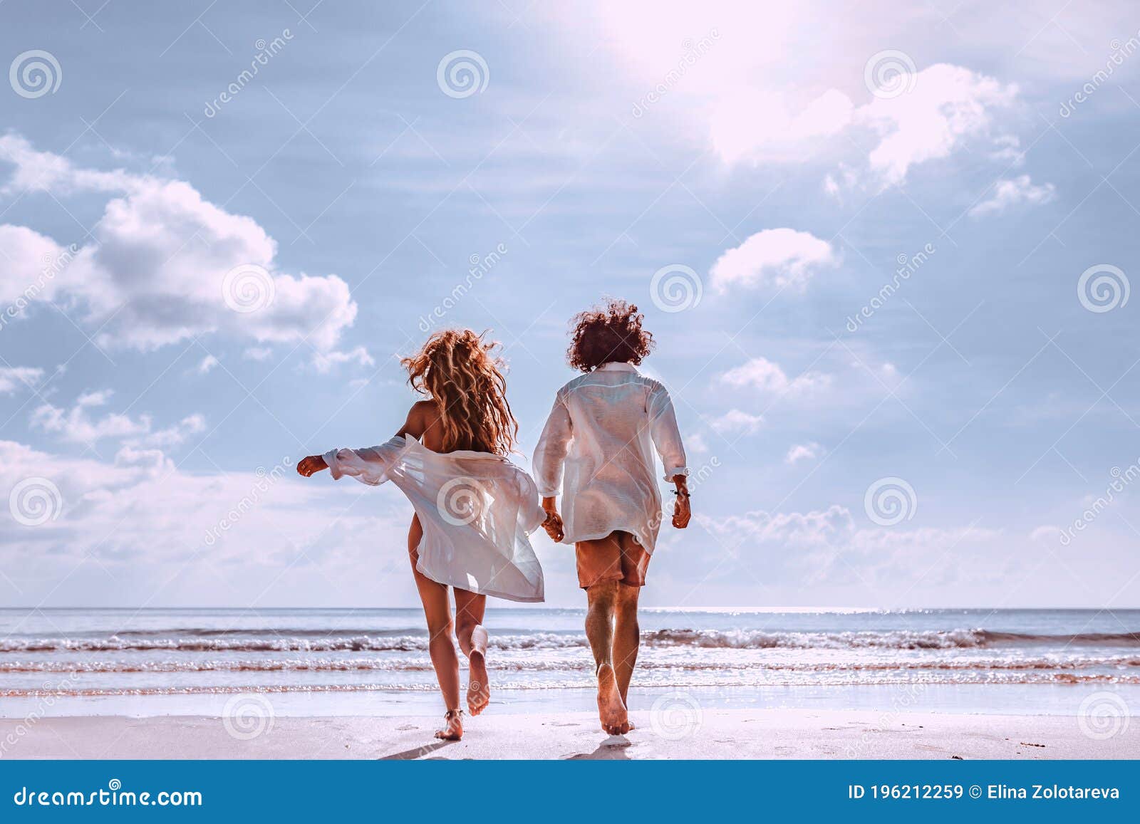 Cheerful couple having some good time naked on the beach