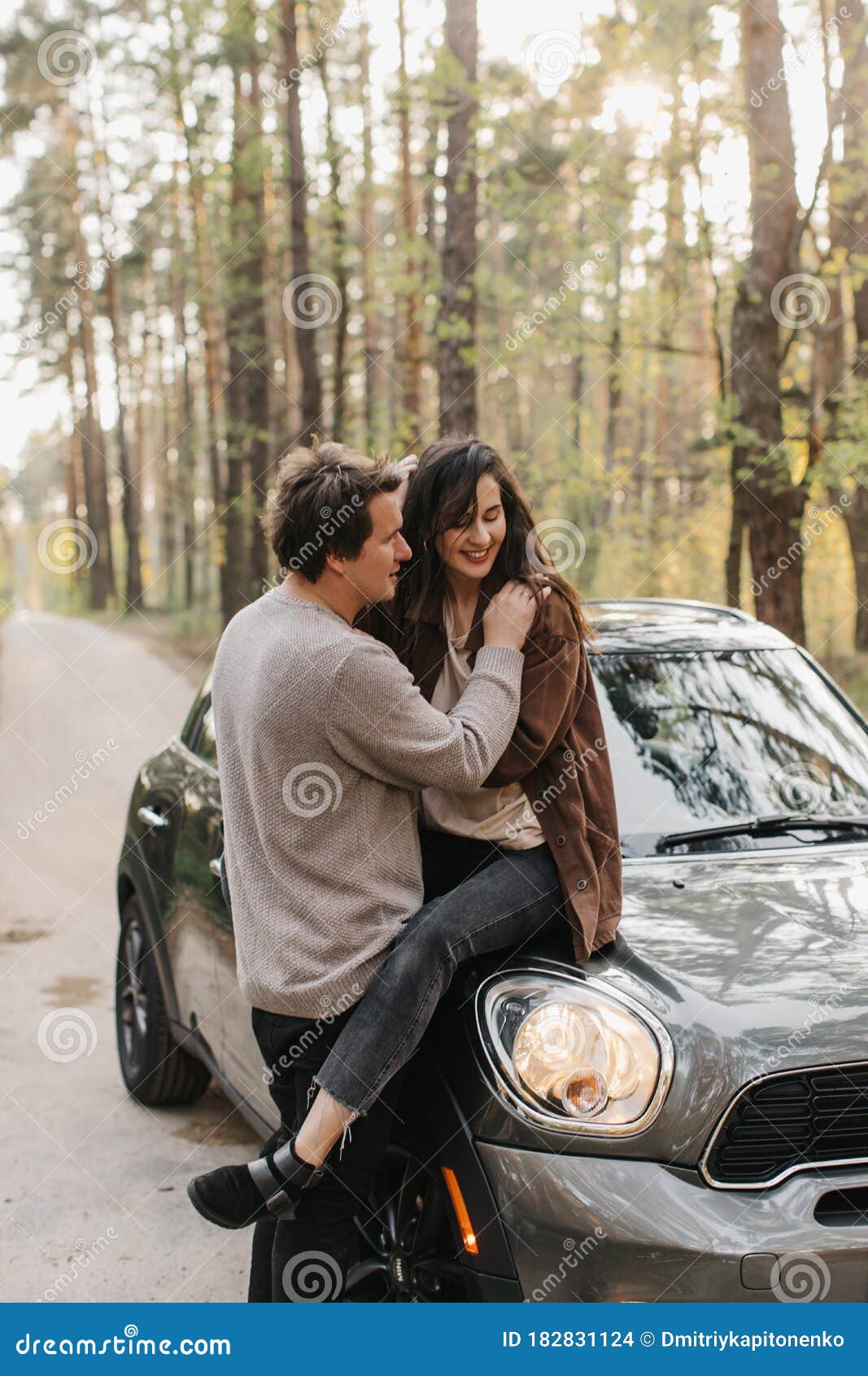 Beautiful Young Couple in Love Kisses and Hugs Sitting on a Car ...