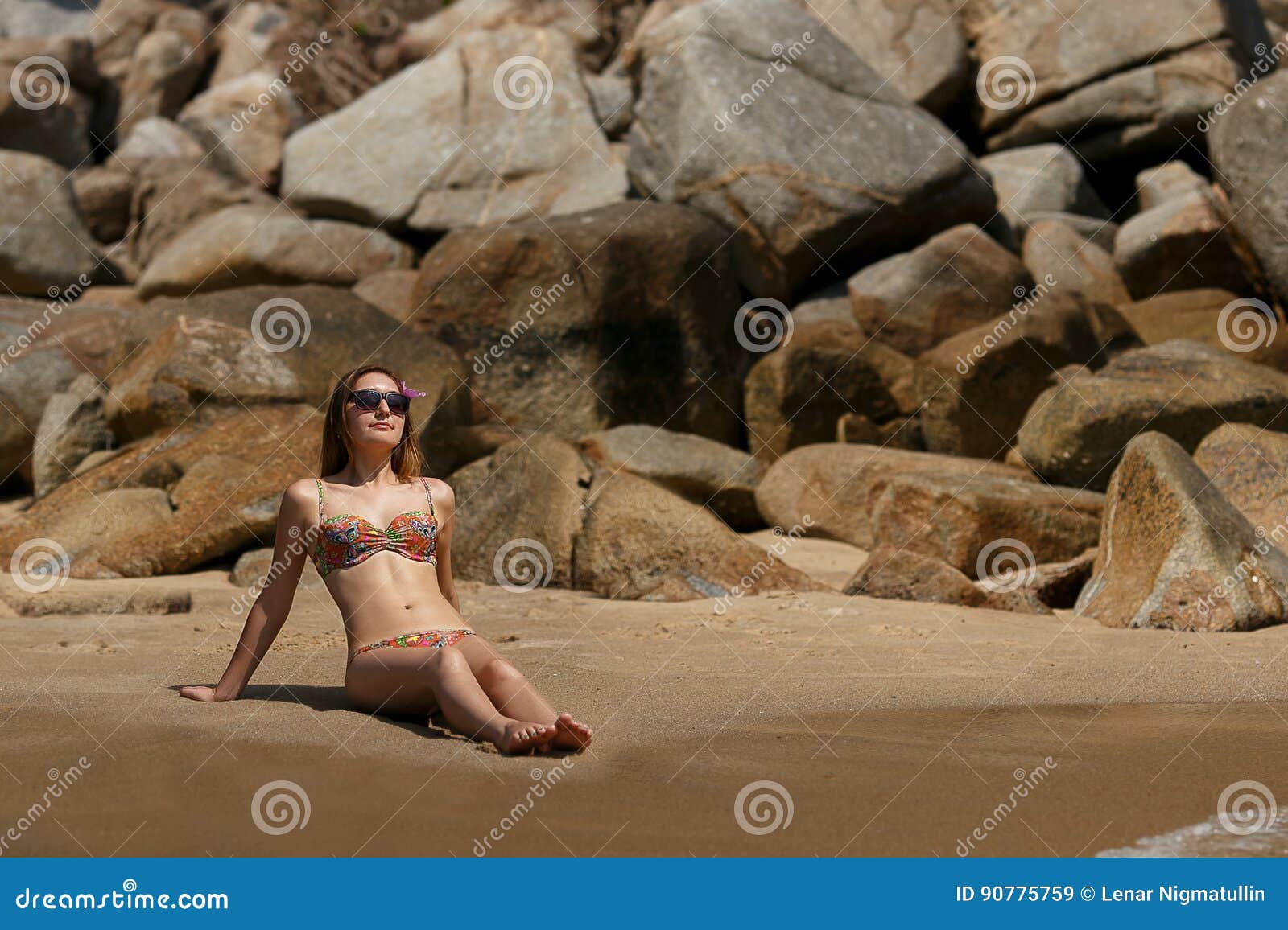 beautiful young girl in bikini sunbathers on the tropical beach.