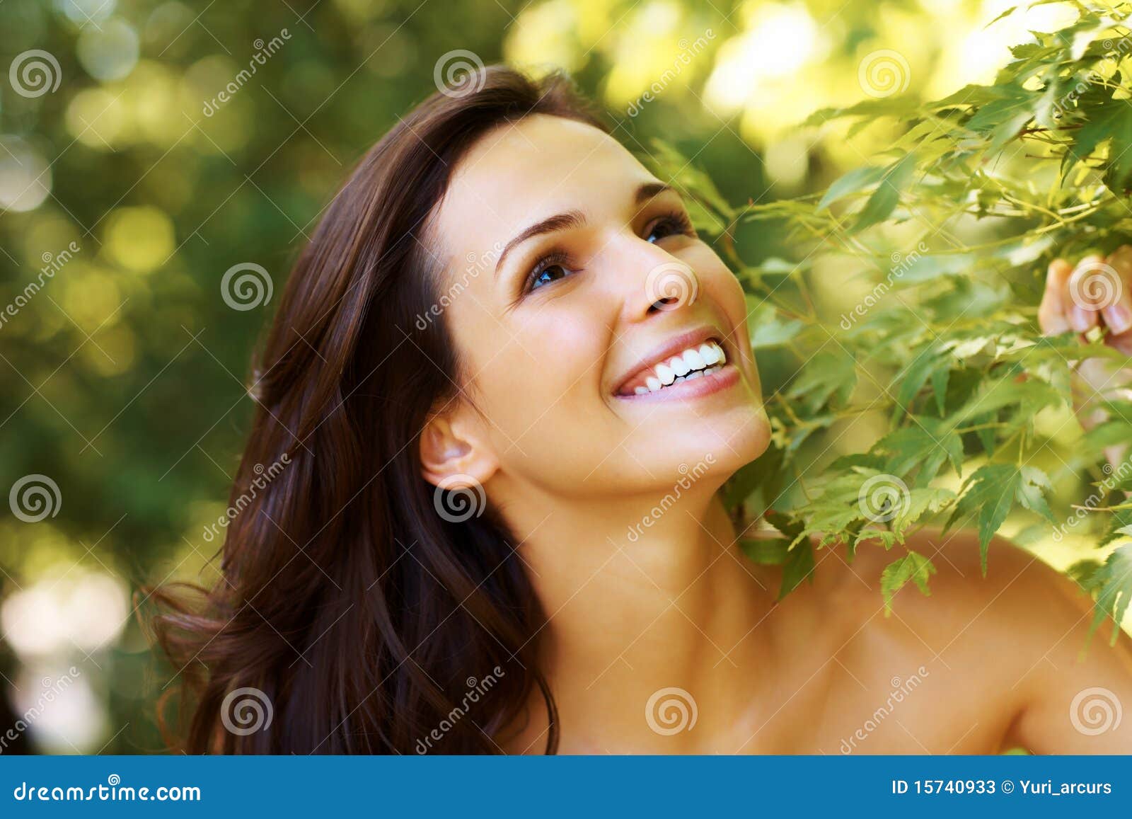 Beautiful young girl looking happy in a park. Closeup portrait of beautiful young girl smiling in the park and looking up - Outdoor