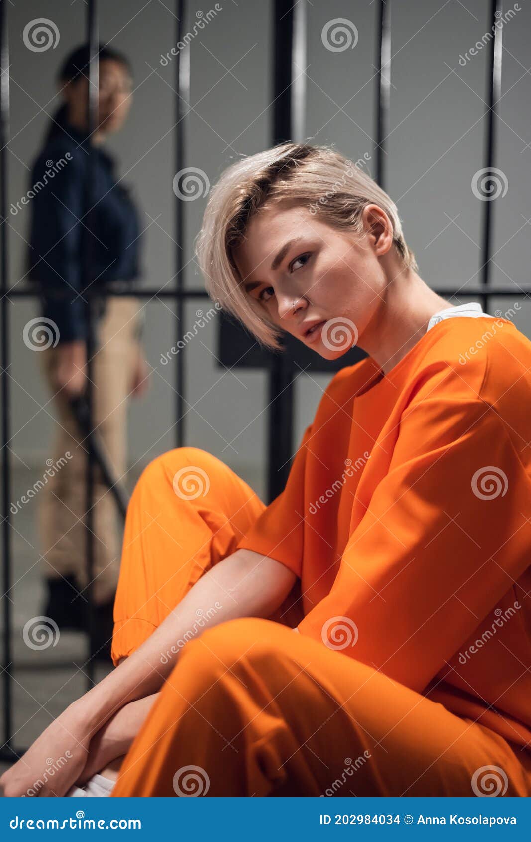 Asian Warden And A Female Prisoner In A High Security Prison Stand In Front Of An Open Cell 