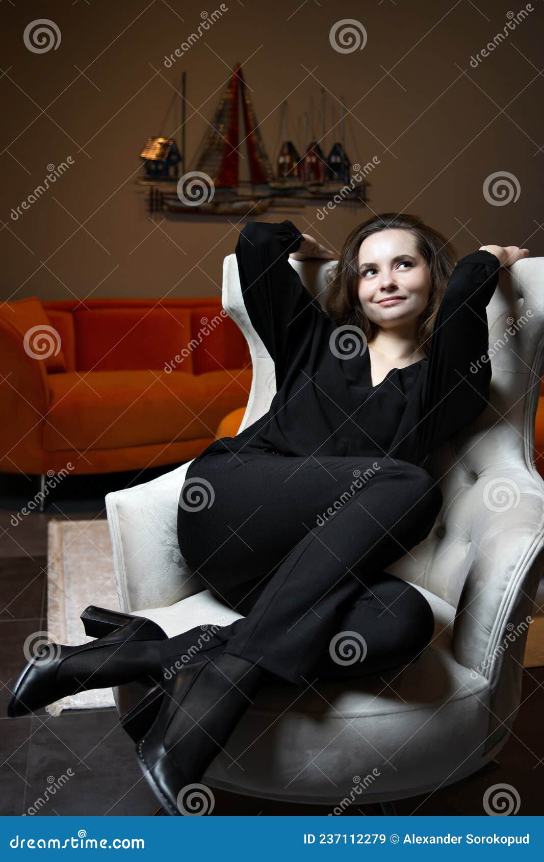 beautiful young girl posing in a chic white armchair