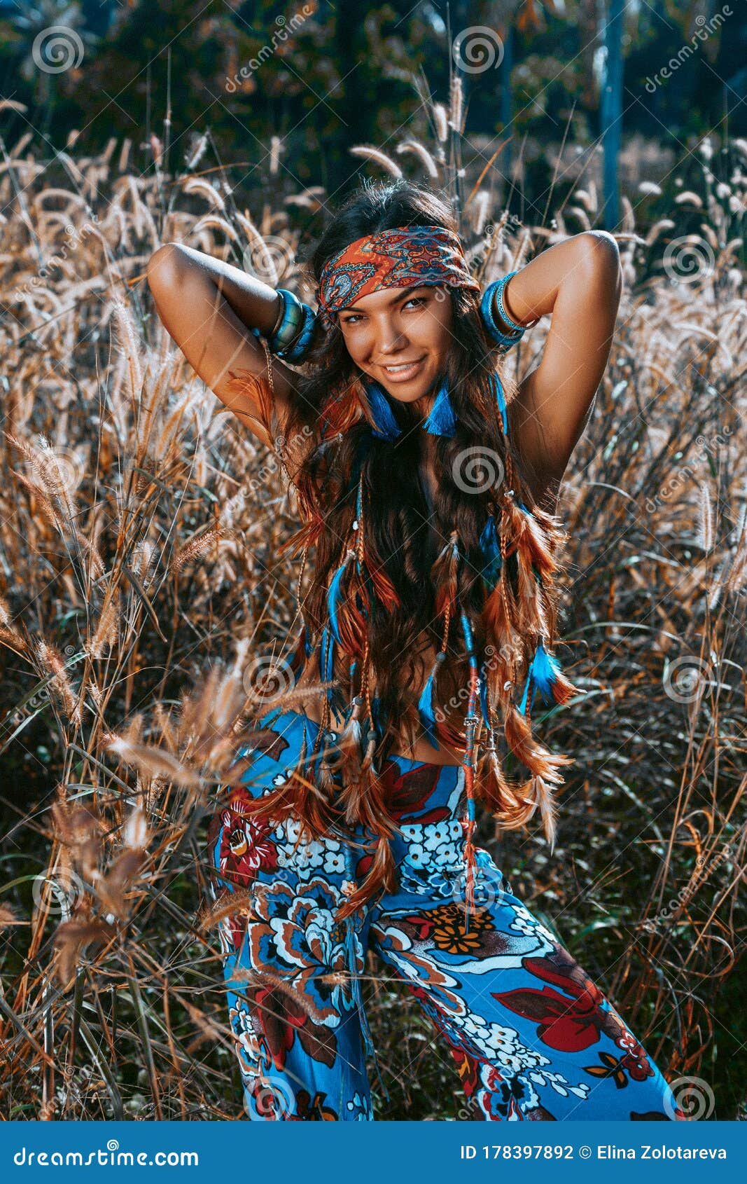 Outdoor portrait of the smiling cute young boho (hippie) girl in