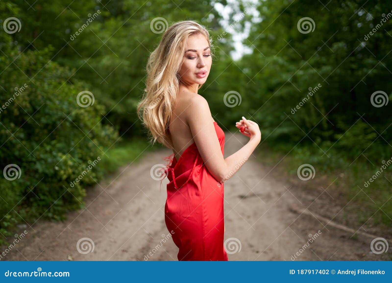 Beautiful Young Long-haired Blonde in a Red Dress Posing on the Road in ...