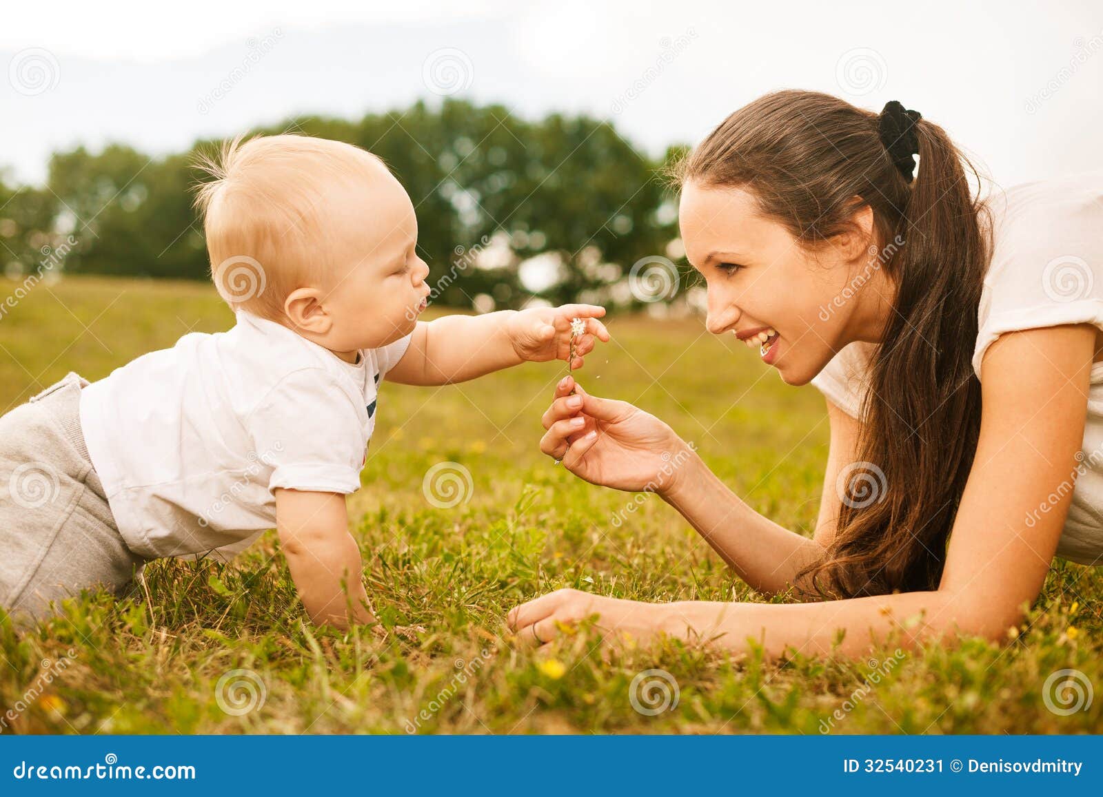 Beautiful Young Mother Giving Flower To Her Baby Stock Image - Image green: 32540231