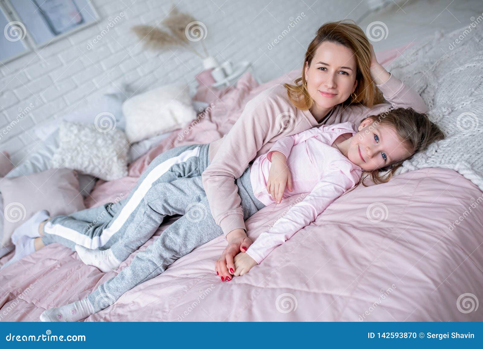 Beautiful Young Mother And Her Little Daughter Are Lying Together On 