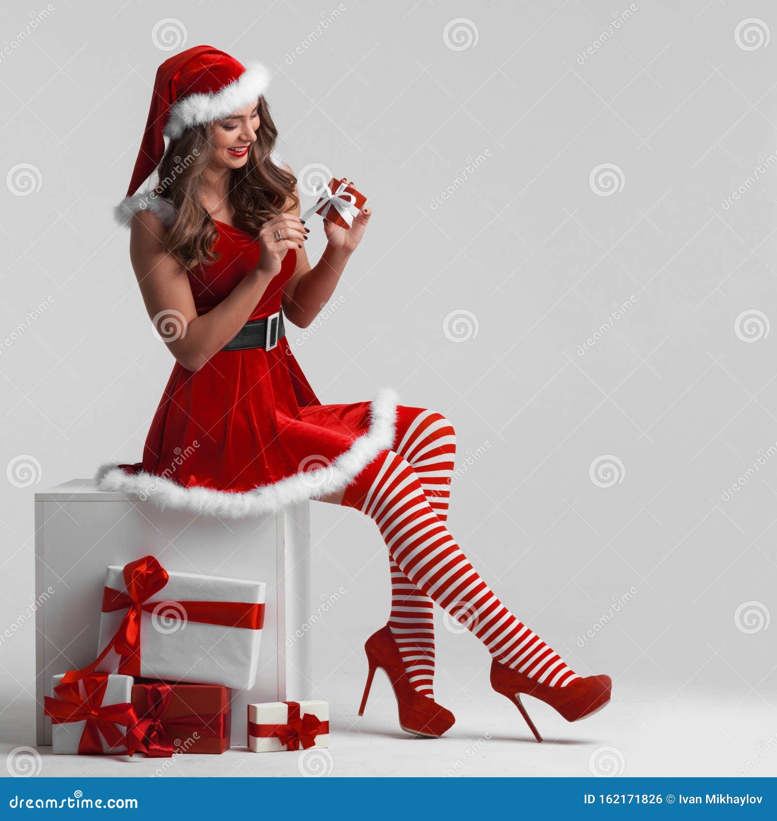 Girl in Santa Dress Unwrapping Gift Stock Photo - Image of beautiful,  pretty: 162171826