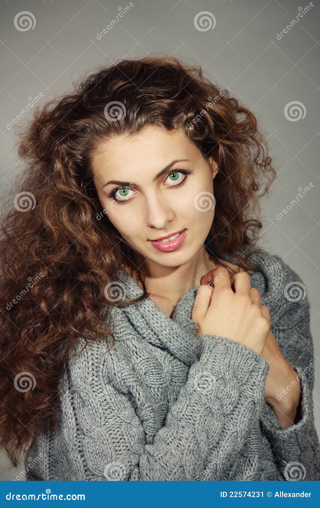 Portrait. Beautiful young woman in a gray sweater with a gray background