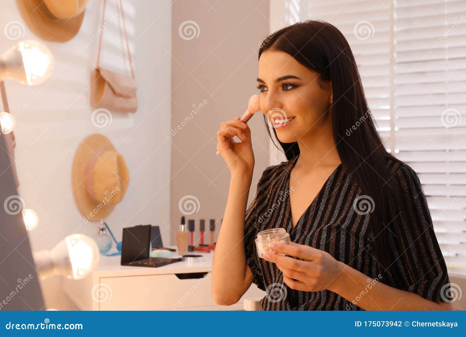 Beautiful Young Woman Applying Makeup Near Mirror In Room ...