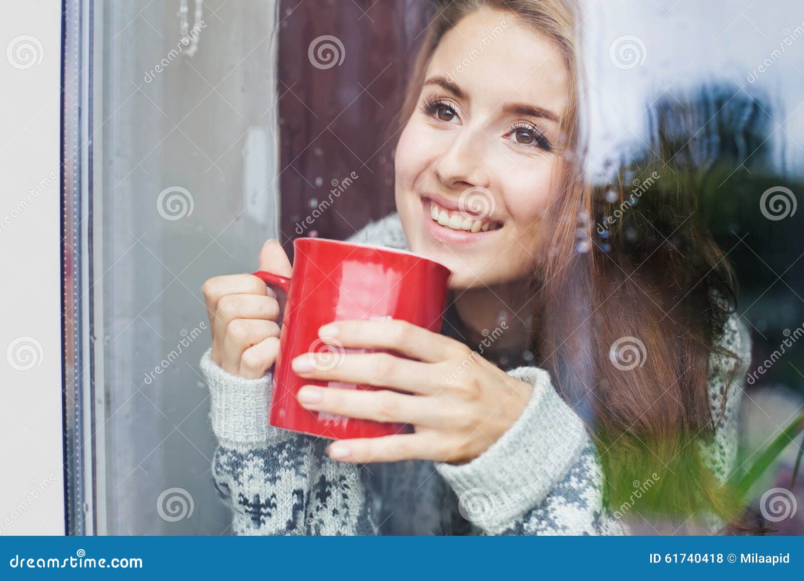 beautiful young woman on a balcony enjoing morning with cup of coffee