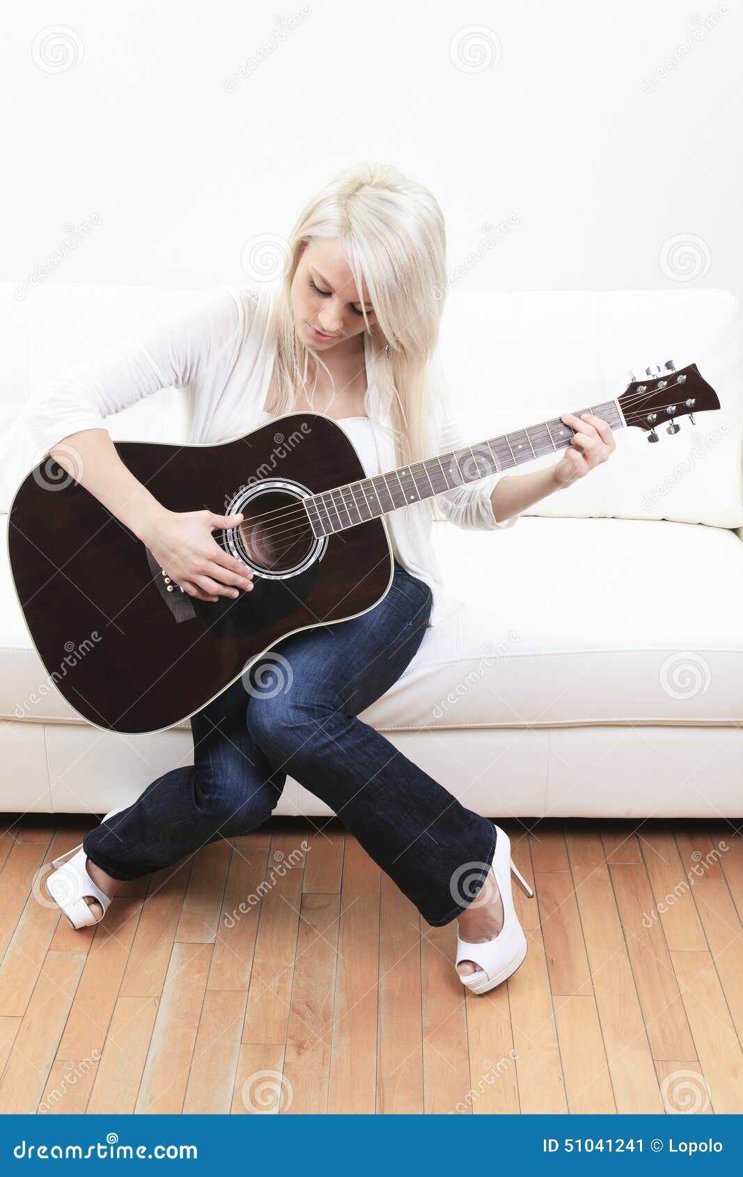 beautiful young woman on the couch with a guitar