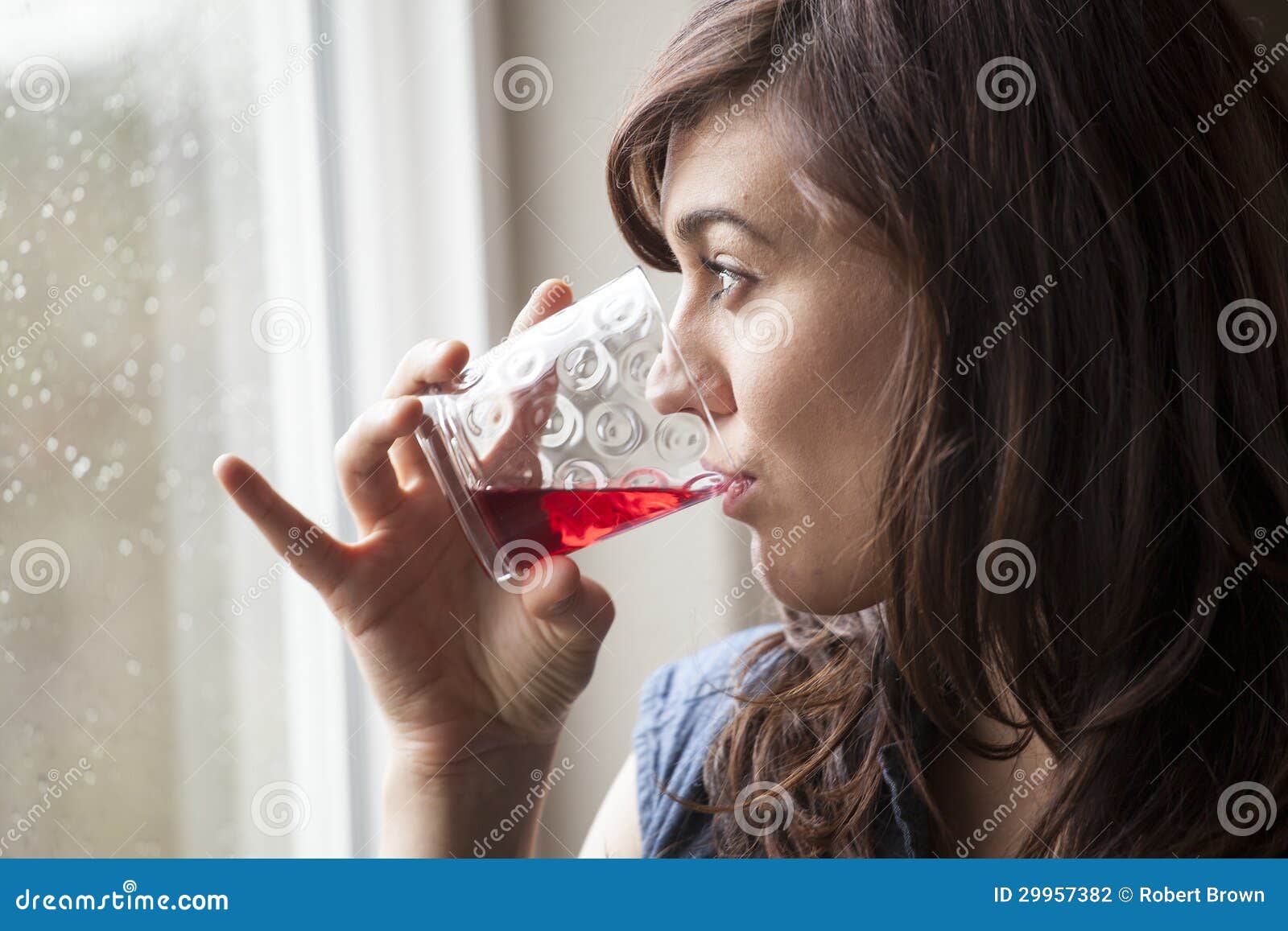beautiful young woman drinking glass of cranberry juice