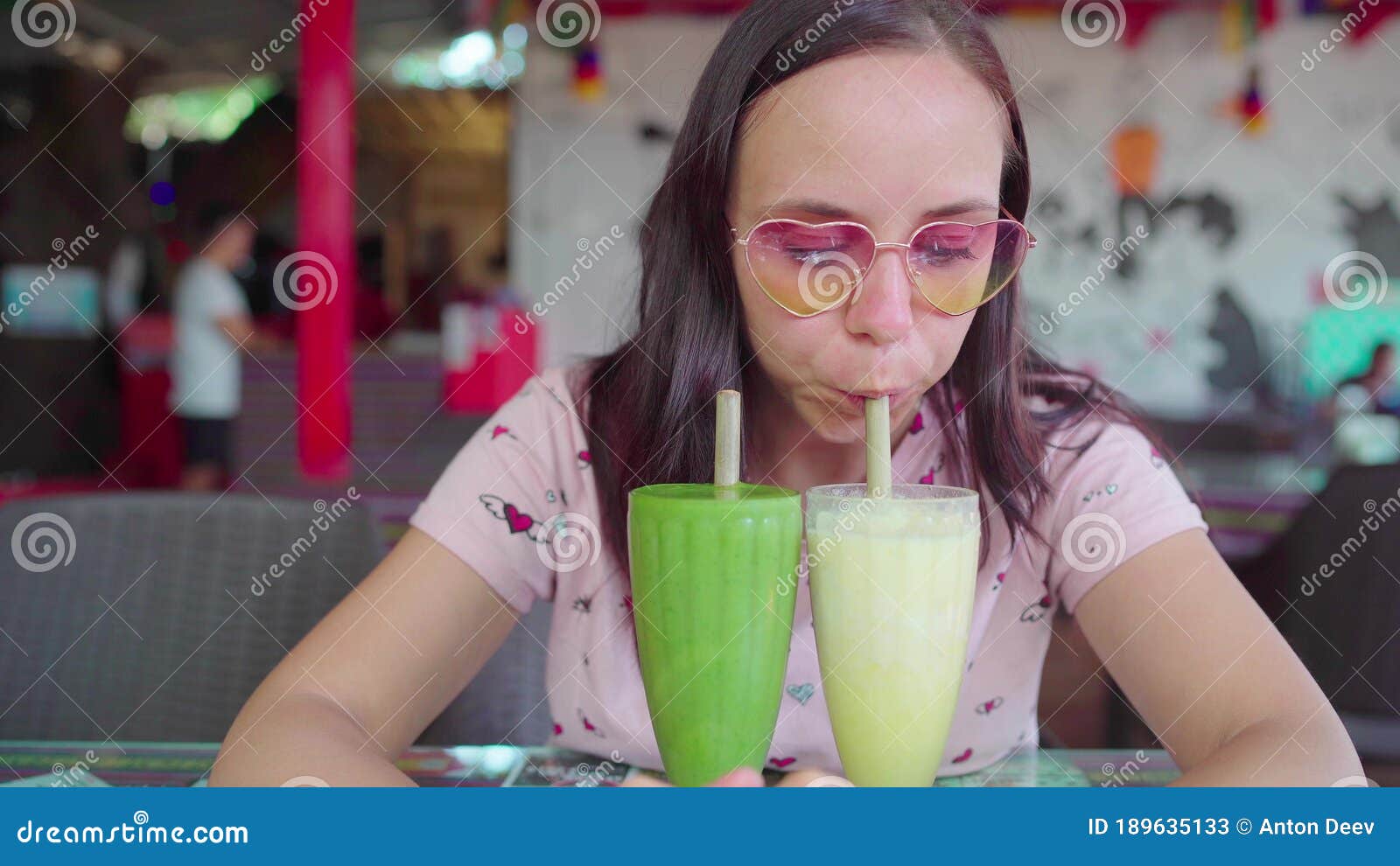 A Beautiful Young Woman Is Drinking The Healthy Smoothies In A Tropical Cafe The Girl Is 