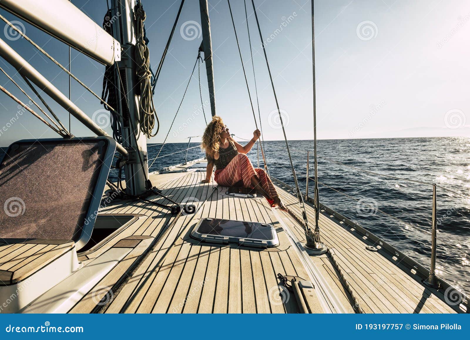 beautiful young woman enjoy summer holiday vacation or excursion on sailboat with sun and ocean around - people enjoying life and