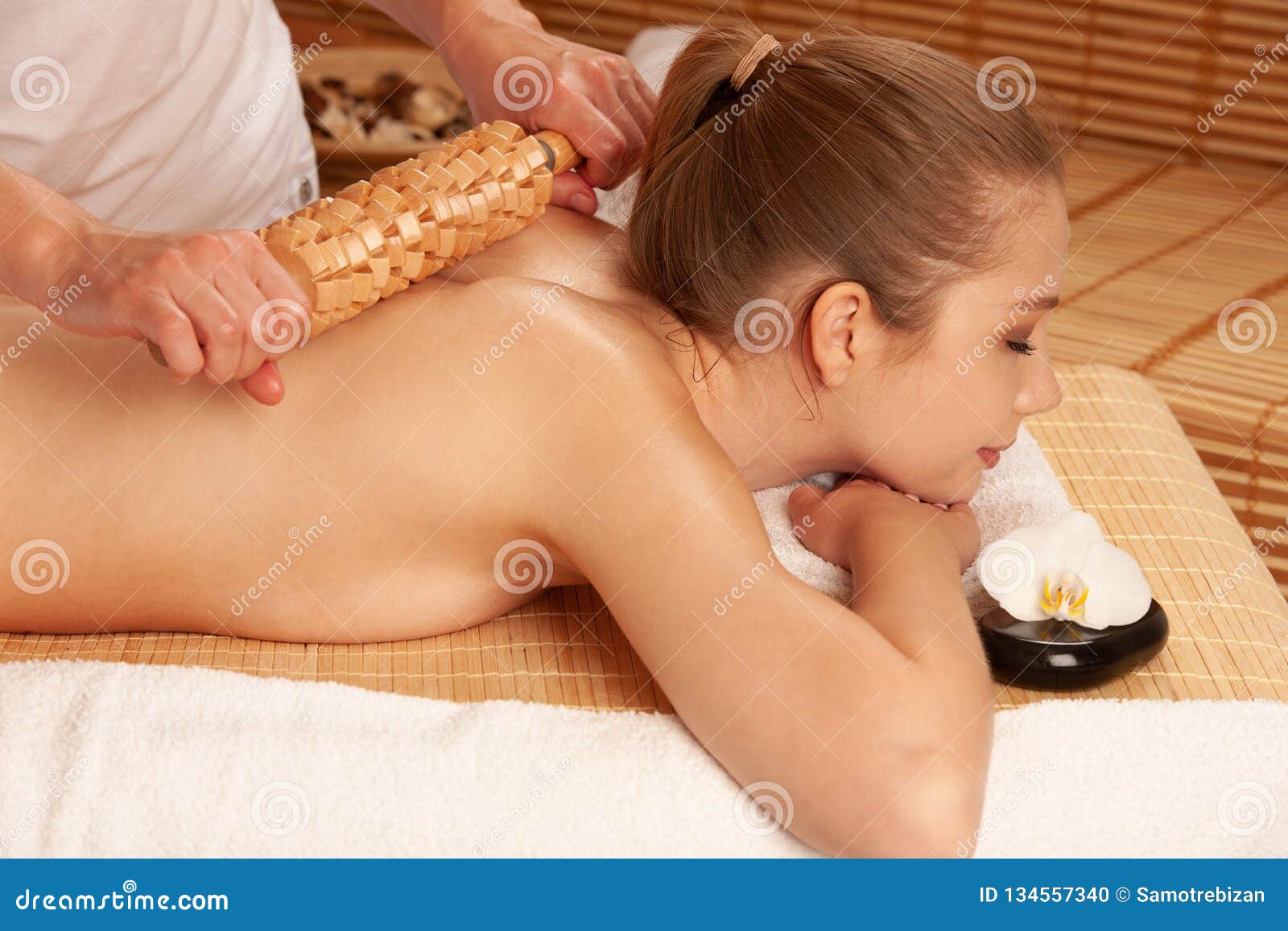 beautiful young woman having a maderotherapy massage treatment in spa salon - wellness