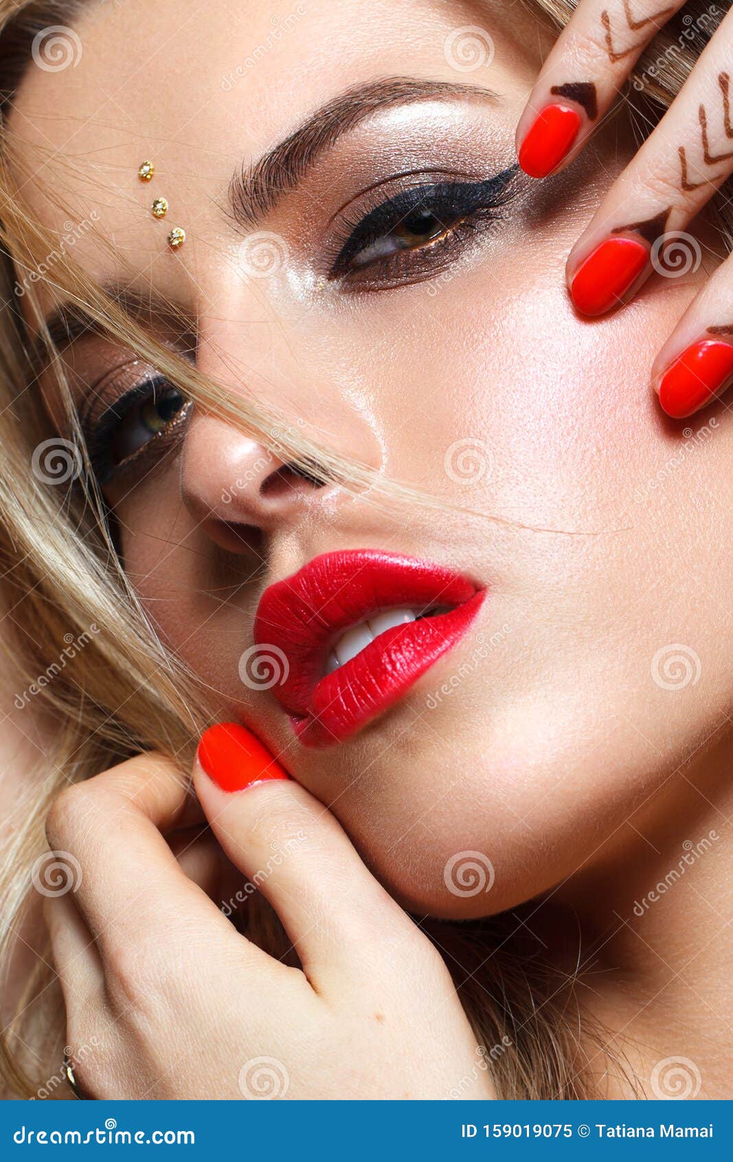 beautiful young woman with a professional colorful make-up, trendy bindi on her forehead.