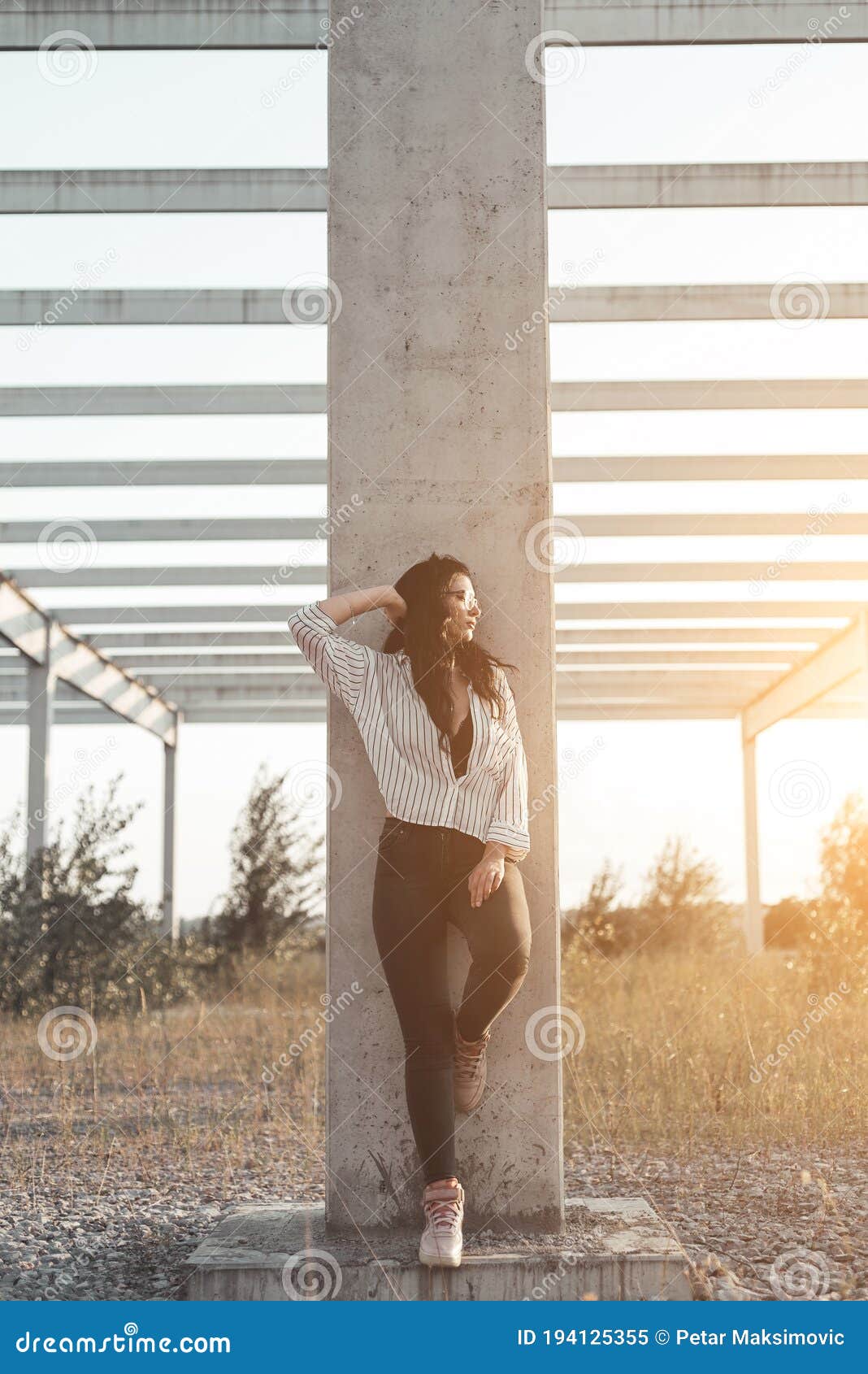 Beautiful Young Woman Leaning on Concrete Post Posing Vertical Stock