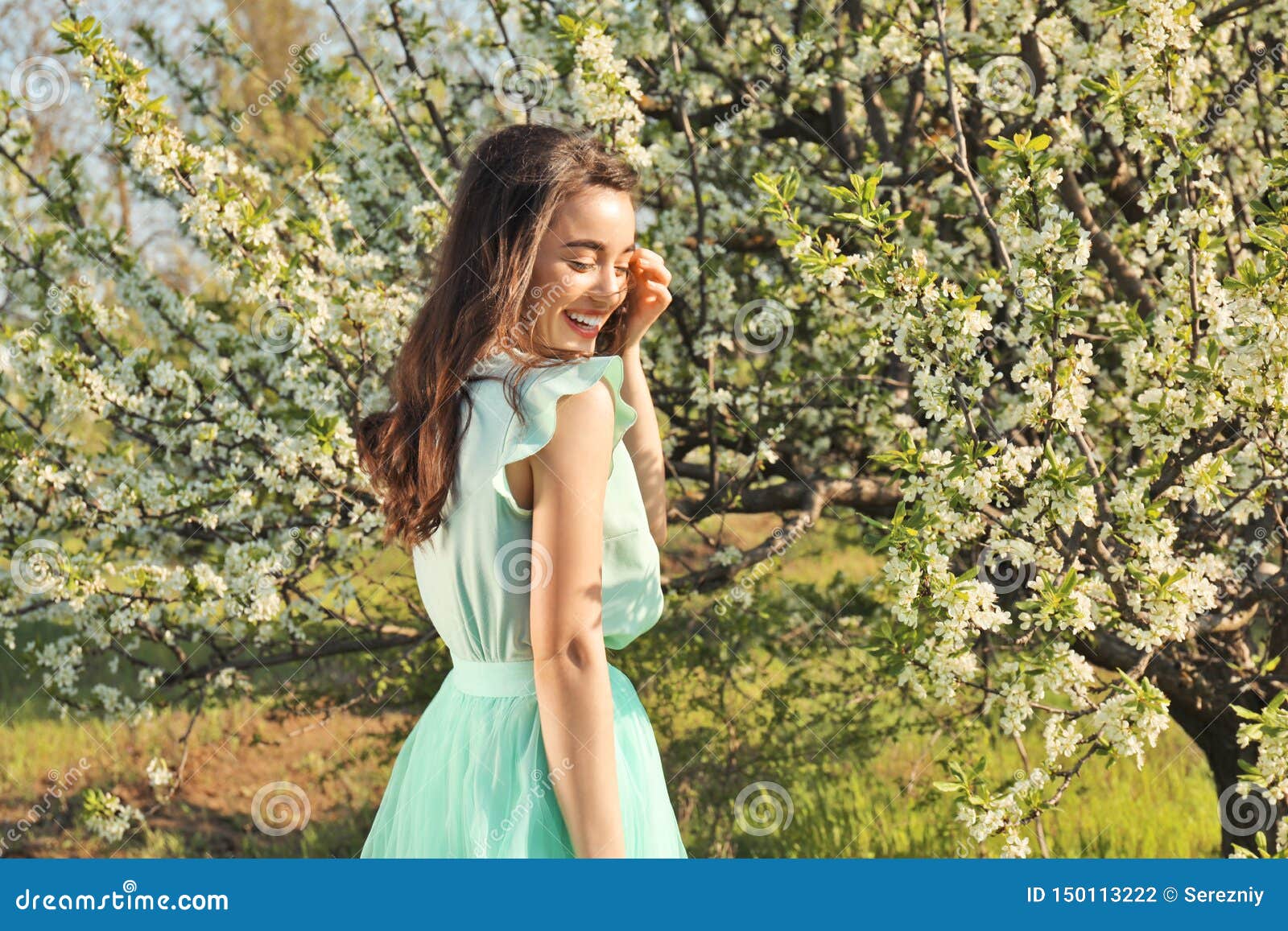 Beautiful Young Woman Near Blossoming Tree On Sunny Spring Day Stock