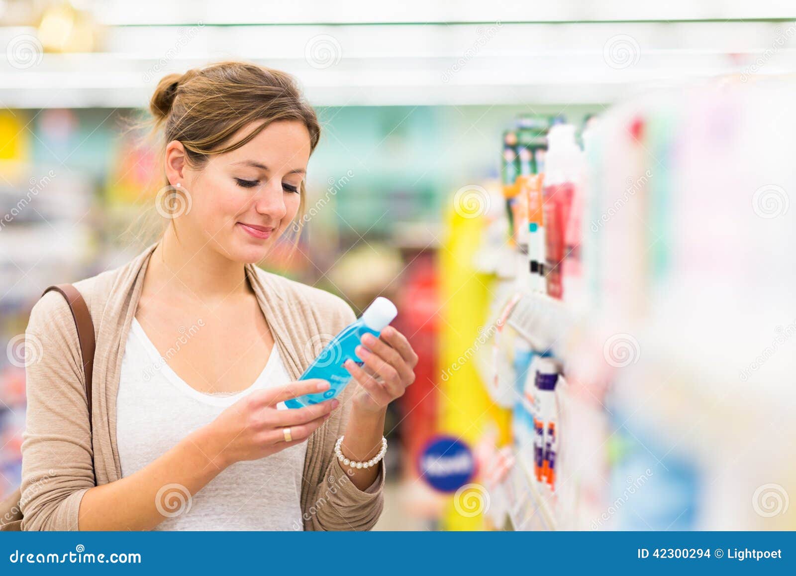 beautiful young woman shopping for cosmetics in a grocery store