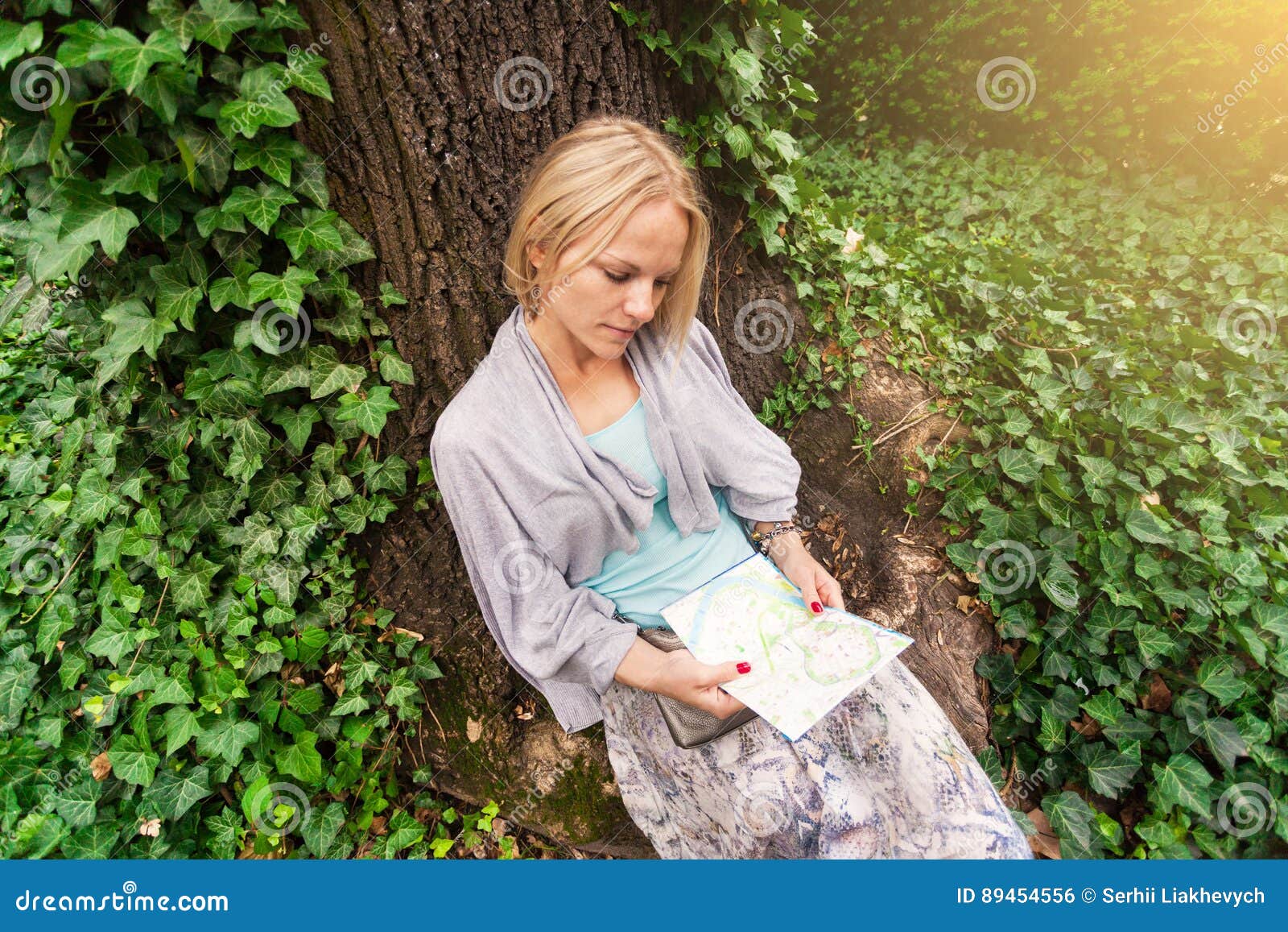 Beautiful Young Woman Sitting Leaning On A Tree In The Middle Of Ivy ...