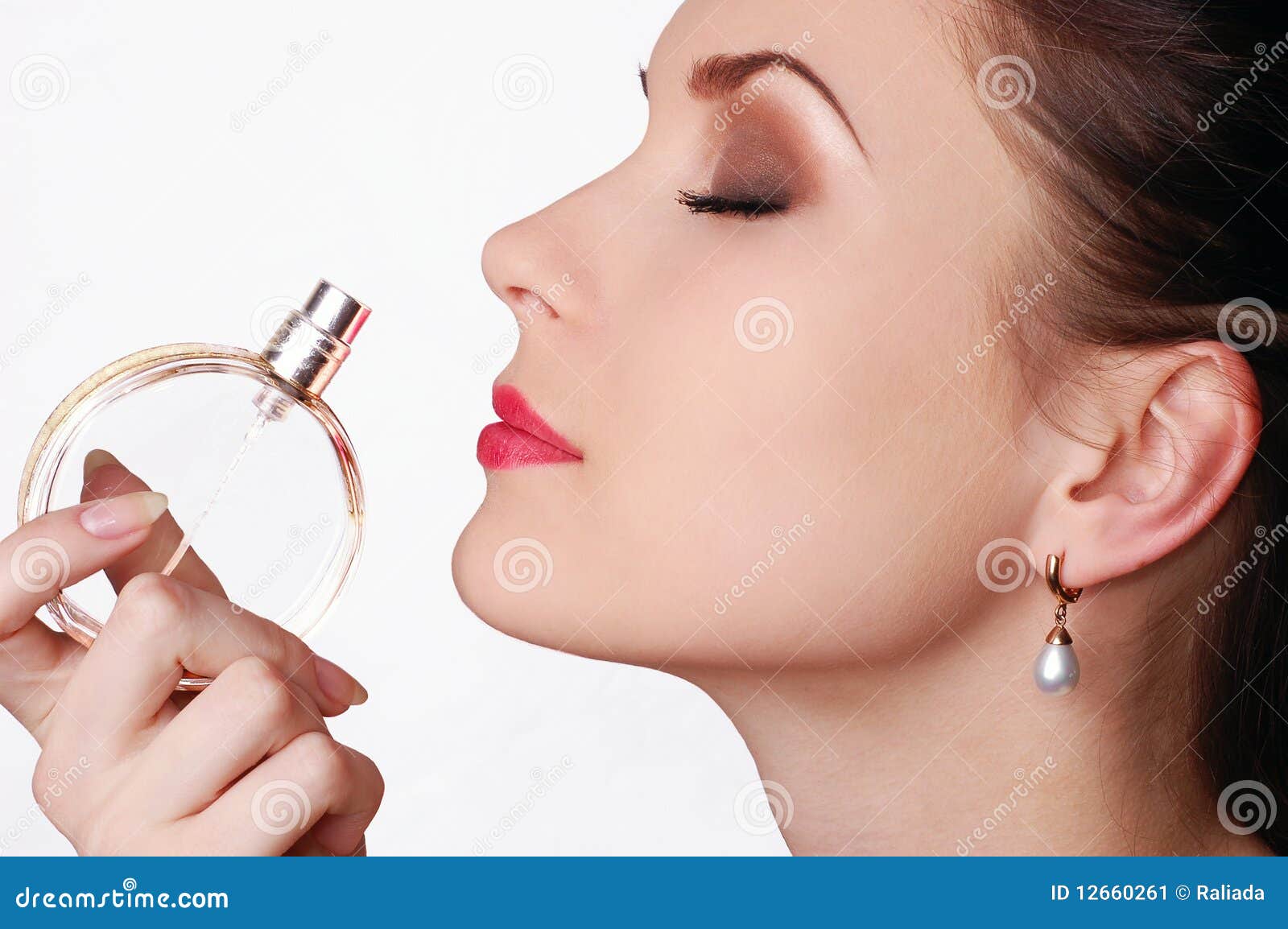 beautiful young woman smelling her perfume