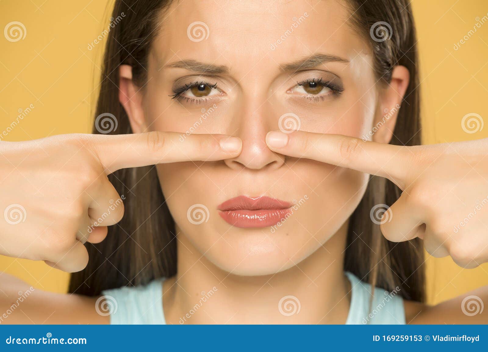 beautiful young woman touching her nose with her fingers
