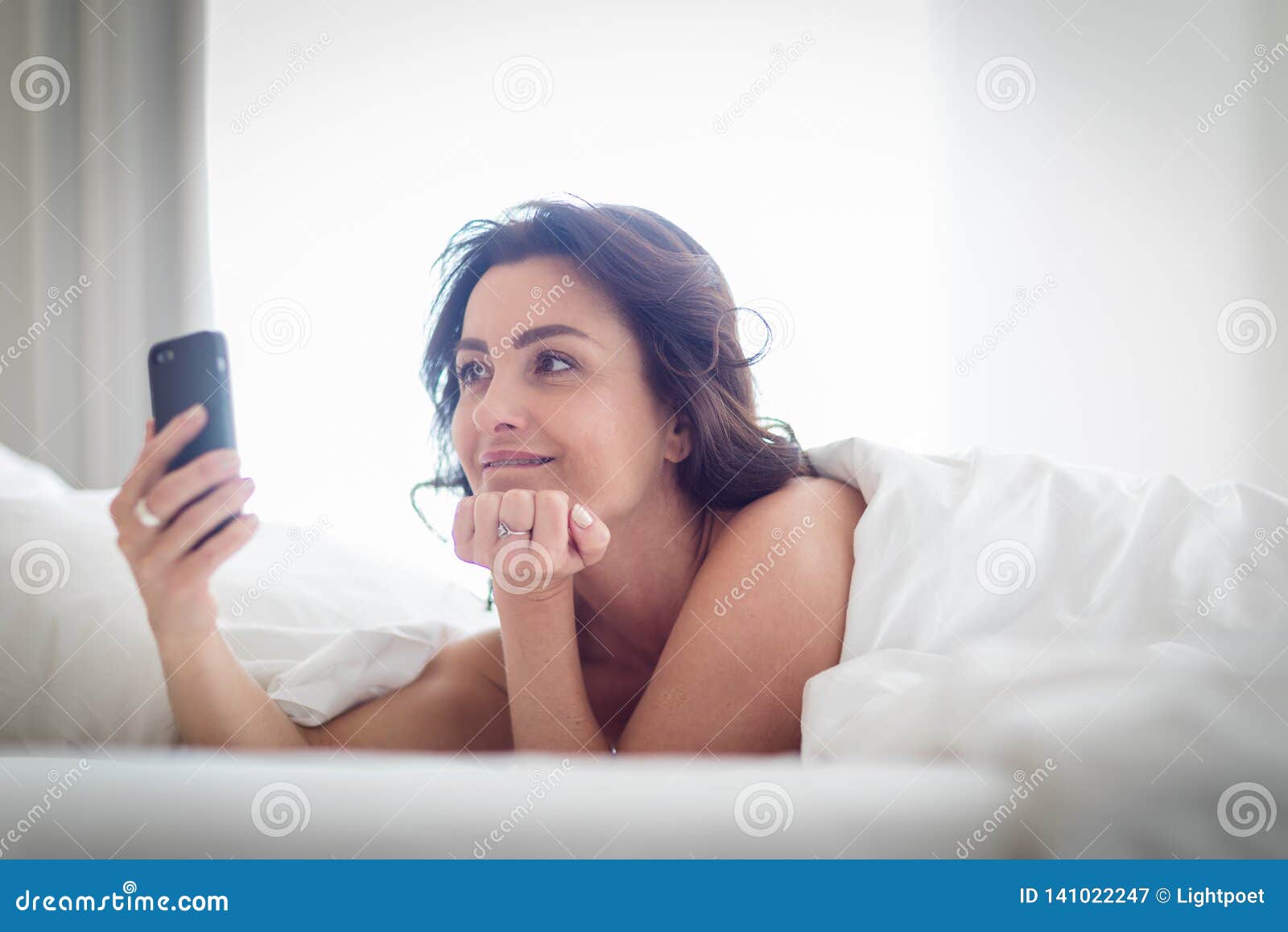 Beautiful Young Woman Using Her Cell Phone In Bed Stock Image Image Of Nightwear Bedroom