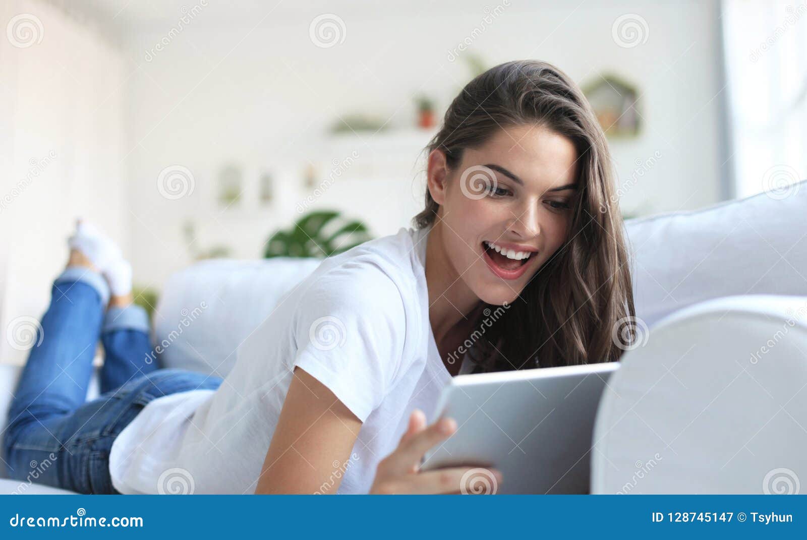 Beautiful Young Woman Using Tablet Sitting on Sofa at Home at Living ...