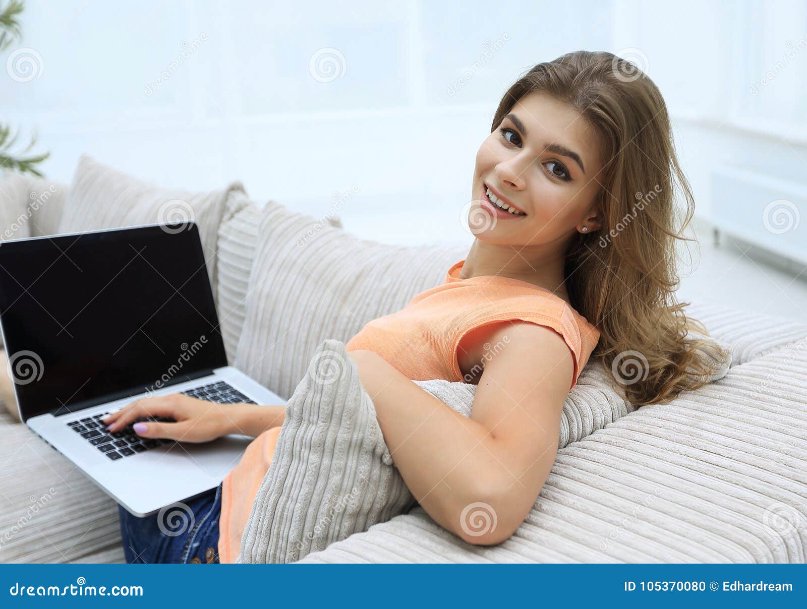 Beautiful Young Woman Working with Laptop Sitting on Sofa and Looking ...