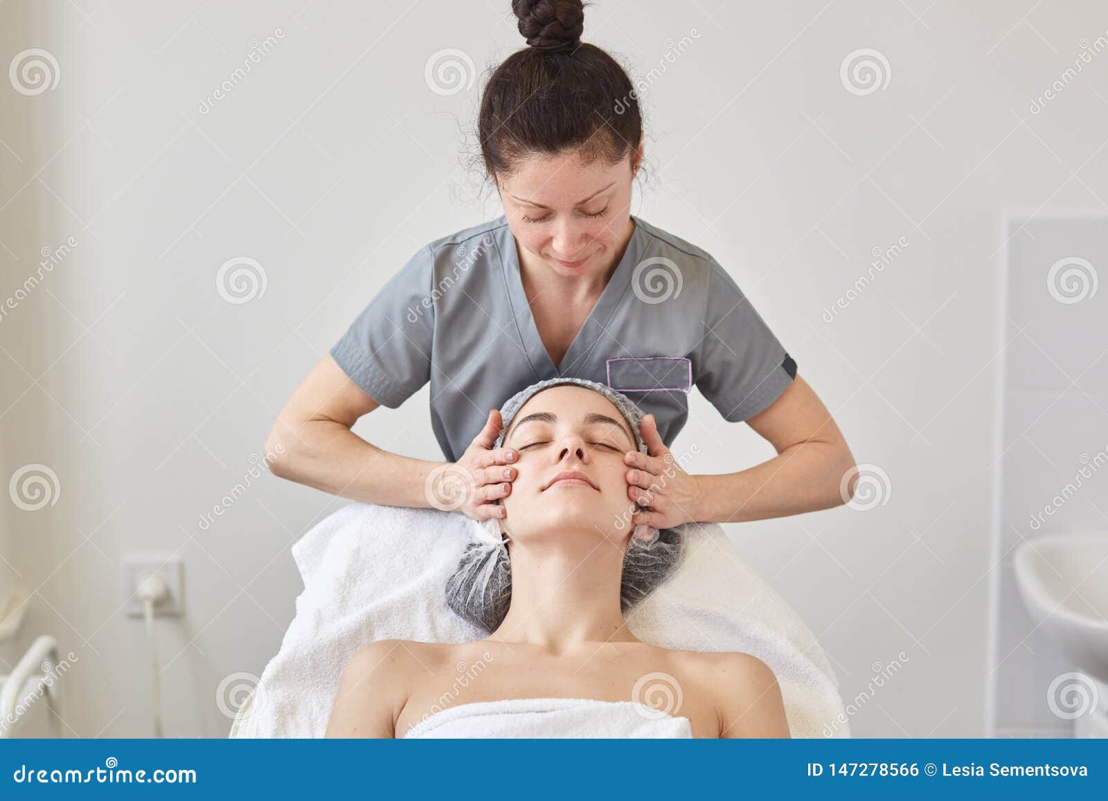 Beautiful Young Woman Relaxing With Face Massage At Beauty Spa While Lying On Comfortable Couh