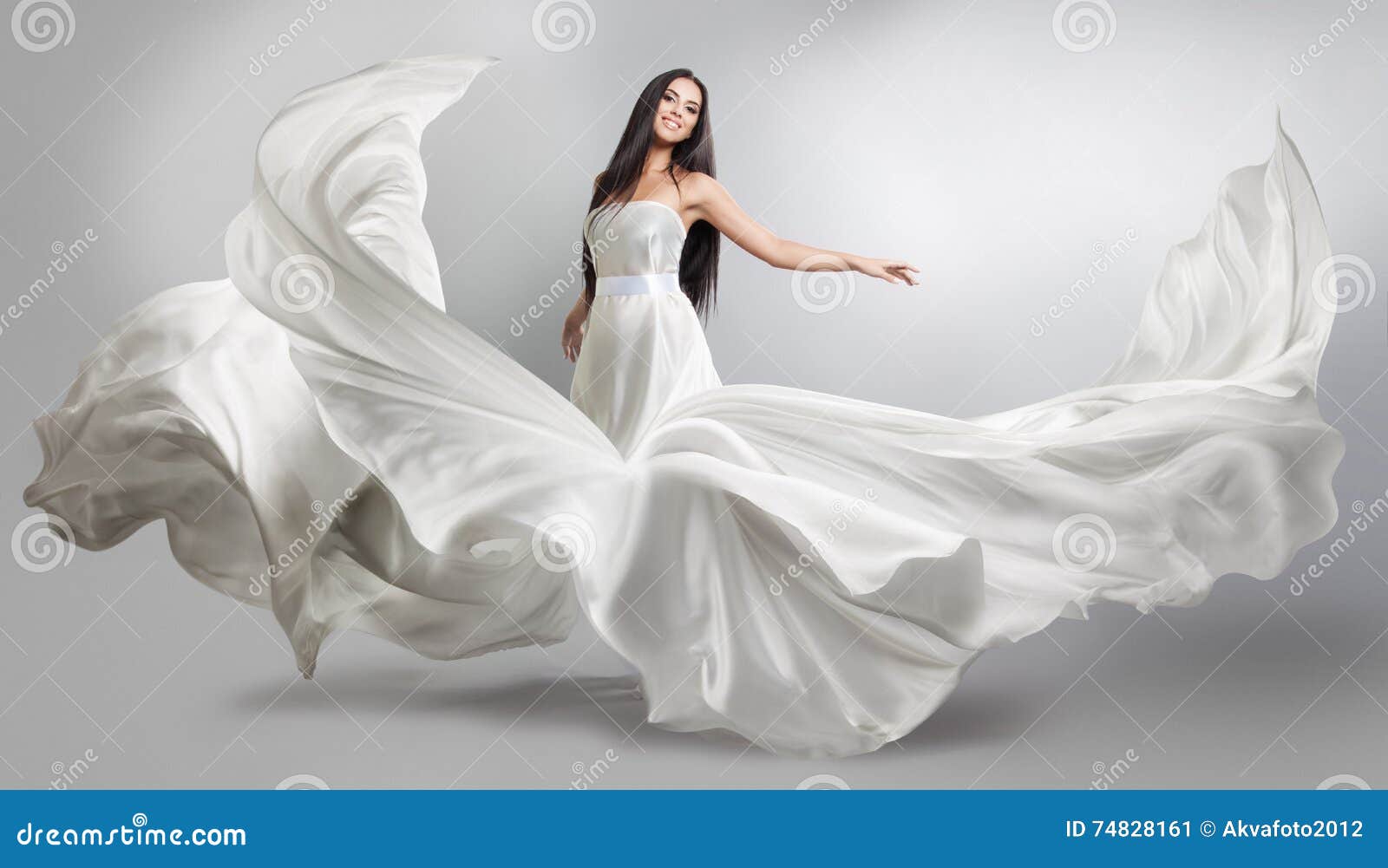 beautiful young girl in flying white dress. flowing fabric. light white cloth flying