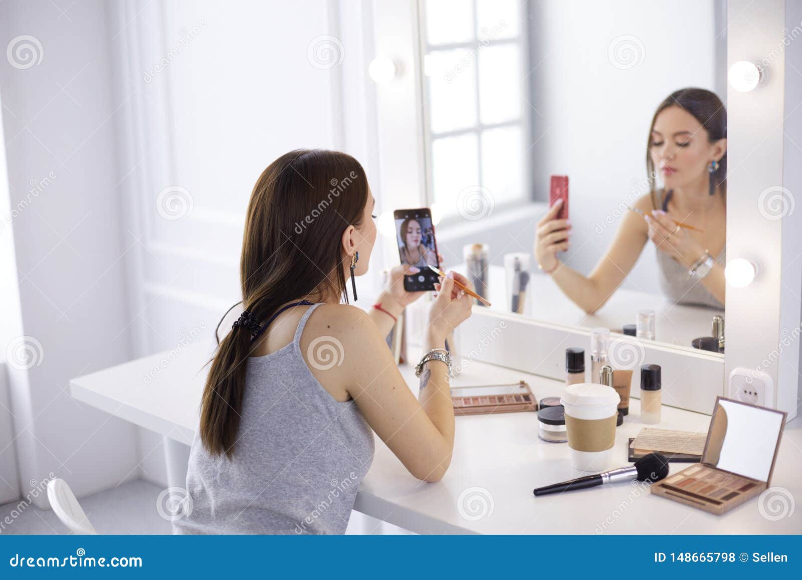 Beauty Blogger Filming Makeup Tutorial with Smartphone in Front of