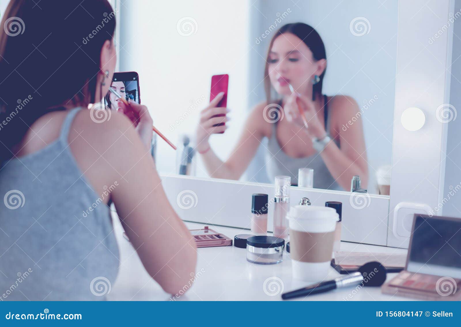 Beauty Blogger Filming Makeup Tutorial with Smartphone in Front of