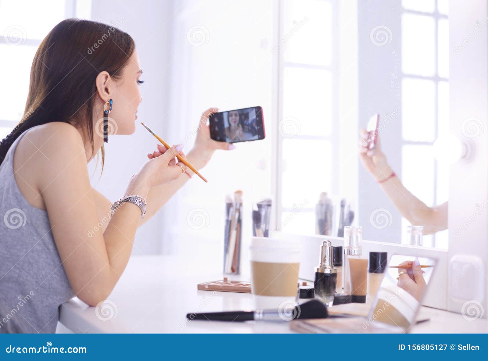 Beauty Blogger Filming Makeup Tutorial with Smartphone in Front of
