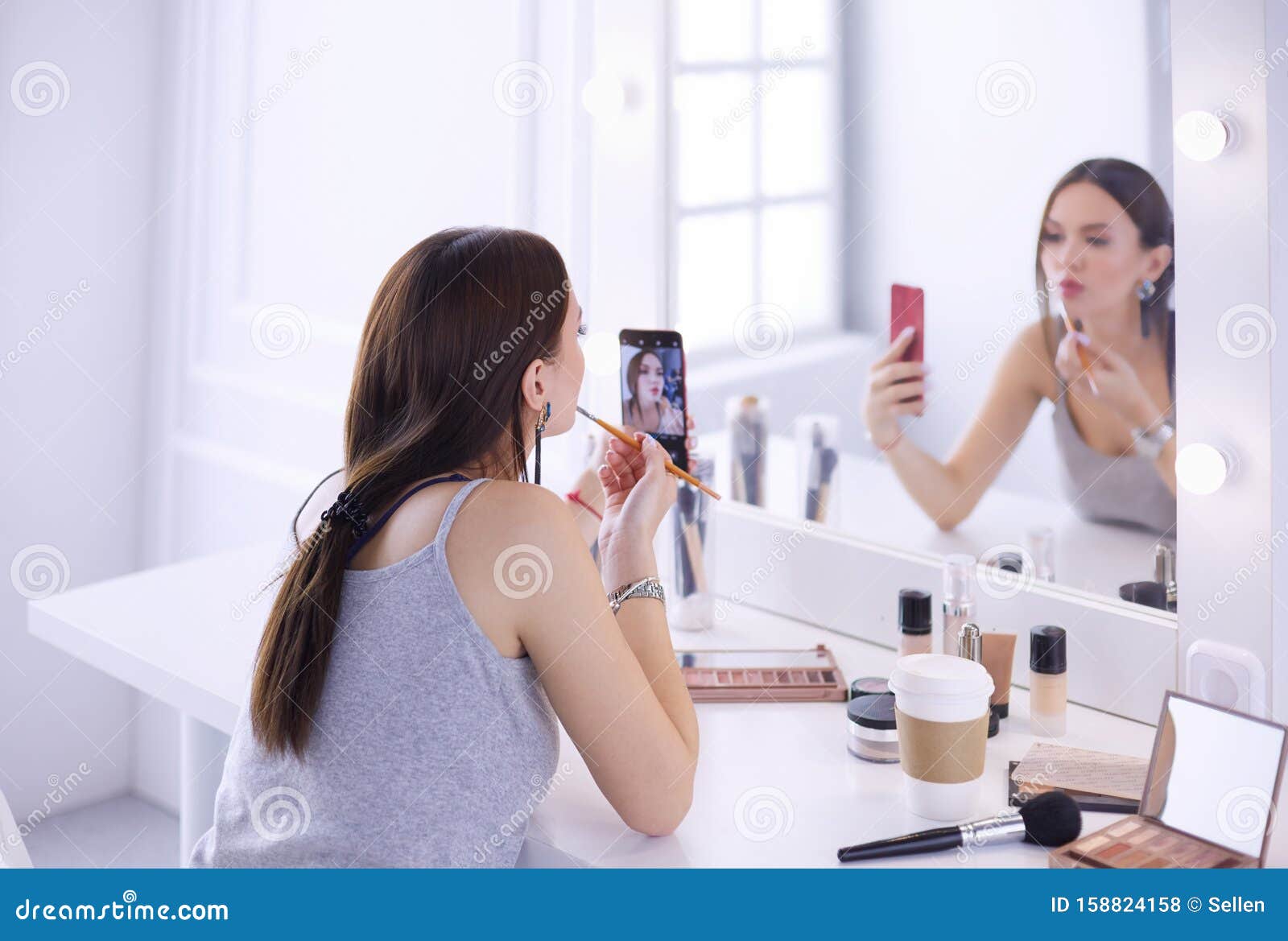Beauty Blogger Filming Makeup Tutorial with Smartphone in Front of