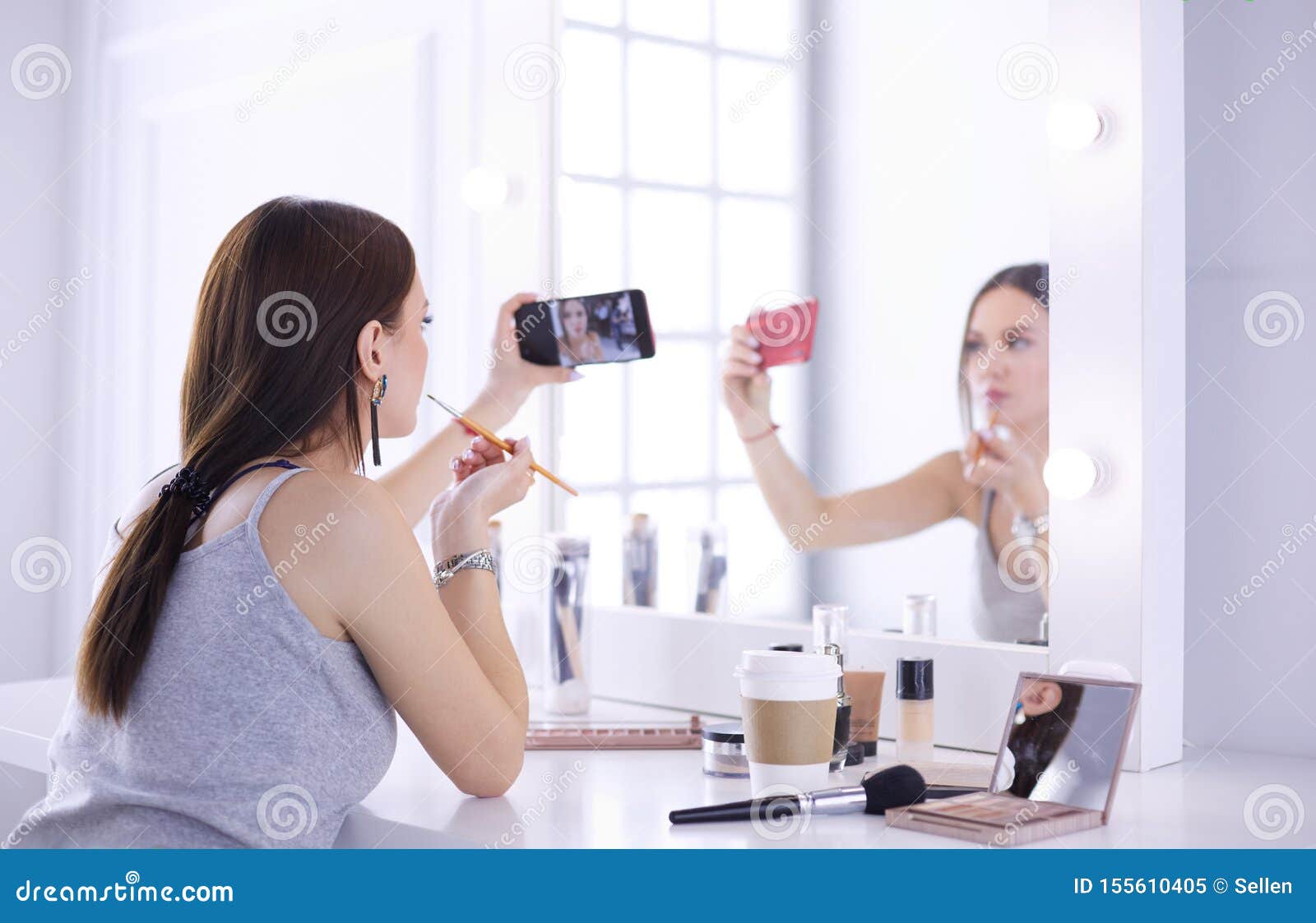 Beauty Blogger Filming Makeup Tutorial with Smartphone in Front of